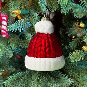 Santa beanie glass ornament hanging on a Christmas tree—red knit cap design with white brim and pompom Santa beanie glass ornament hanging on a Christmas tree—red knit cap design with white brim and pompom