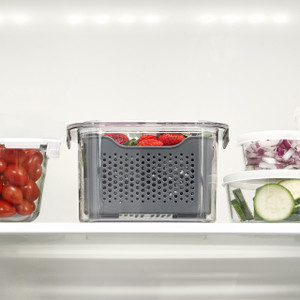 Fresh Keeper storage container with vented inner basket holding strawberries on a refrigerator shelf Fresh Keeper storage container with vented inner basket holding strawberries on a refrigerator shelf