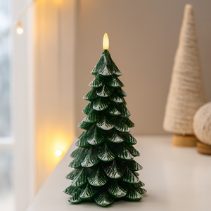 A Green Christmas Tree Flameless Candle, sculpted from paraffin wax and dusted with faux snow, is glowing warmly on a tabletop as part of a cozy, modern holiday decor arrangement. A Green Christmas Tree Flameless Candle, sculpted from paraffin wax and dusted with faux snow, is glowing warmly on a tabletop as part of a cozy, modern holiday decor arrangement.