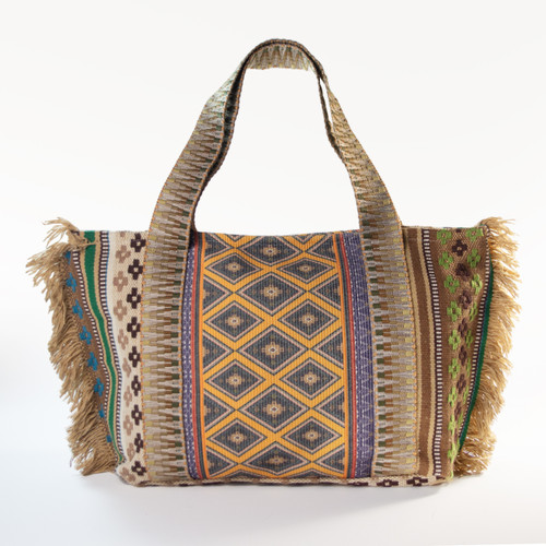 The vibrant, Isla Fringe Large Boho Tote, featuring a bold woven geometric pattern in earthy tones with playful fringe detailing on the sides, is shown against a plain white background.