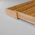 The bamboo bag organizer is displayed with its convenient sliding lid partially open, illustrating how easy it is to load and refill with boxes of storage bags.