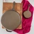 Bottom view of the gold cast iron skillet on white background showing the smooth base and hanging-hole handle.