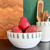 The Northwoods serving bowl is used as a decorative fruit bowl, filled with pomegranates, adding a touch of modern holiday charm to the setting.