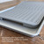 The gray, perforated crisping mat is shown folded in half and resting on top of a metal baking sheet.