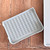 An angled view of the baking and crisping mat folded and standing upright for convenient storage.