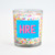 The festive sprinkles inclusion candle in a clear glass jar, shown with a personalized blue label that reads "HRE."
