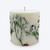 Detail of embedded balsam fir pieces and red berries in white soy wax on the fir and berry inclusion candle
