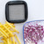 Close-up of the square dicing grid blade insert with french-fry potato sticks and chopped red onion beside it.