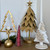 Gold metal leaf Christmas tree styled with bottle brush trees and ornaments in a holiday vignette