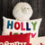 Sheep plush in a holiday vignette with greenery and festive accents