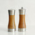 Close-up of the acacia wood salt and pepper mills showing stainless steel tops and bases.