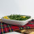 Embossed square stoneware baking dish filled with green beans and lemon slices; oven-to-table baker on plaid cloth