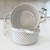 Overhead view of a single embossed stoneware soup bowl with dual handles and matte biscuit finish