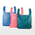 Set of three reusable grocery totes in blue geometric, coral dot, and teal leaf prints standing upright