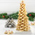 A close-up view of the beautiful, tiered Christmas tree centerpiece made entirely from stacked and decorated snowflake cookies, with some of the stainless steel cookie cutters and loose cookies arranged around its base.