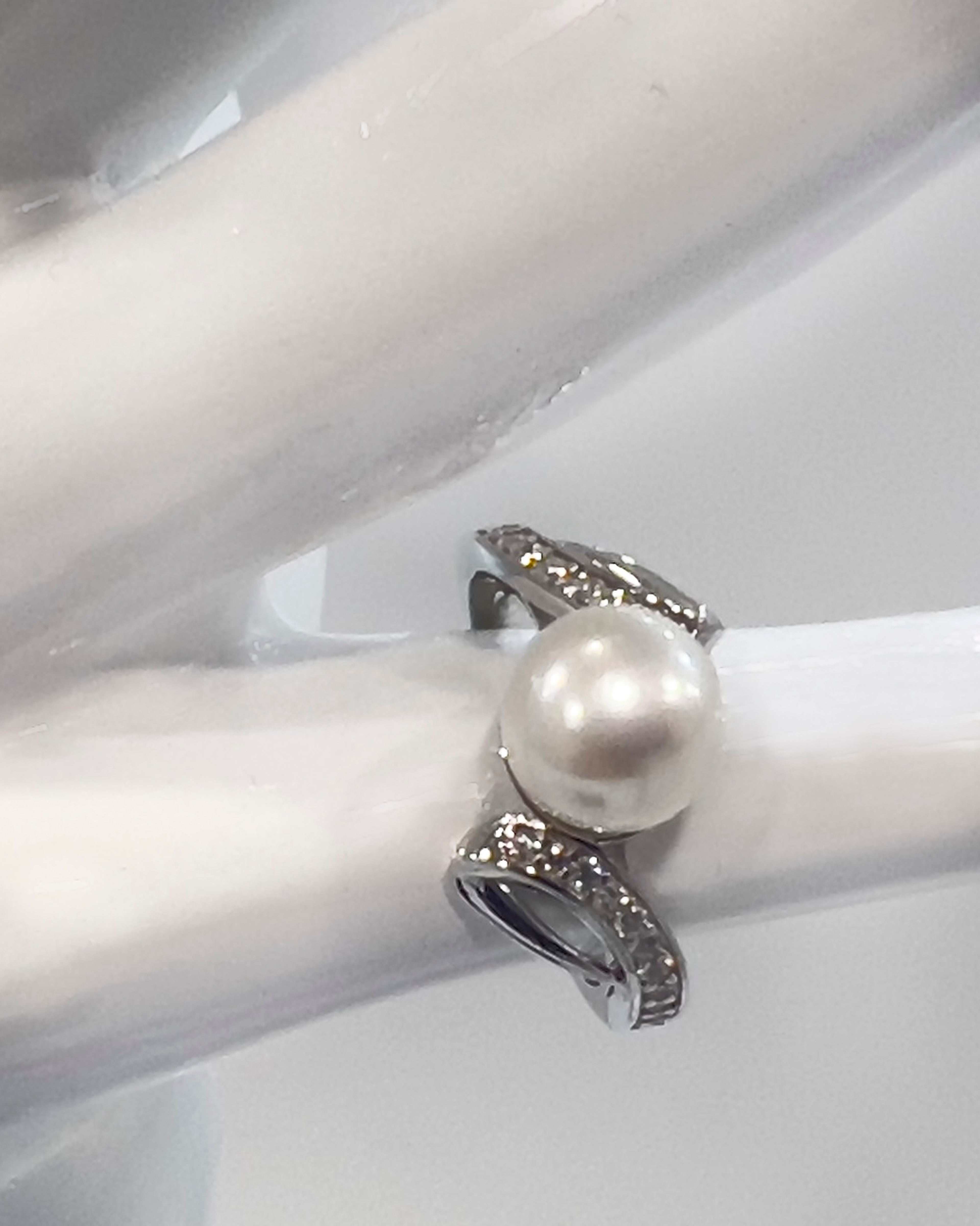 Signature statement ring with a white round pearl and crystal twist on a rhodium-plated silver band