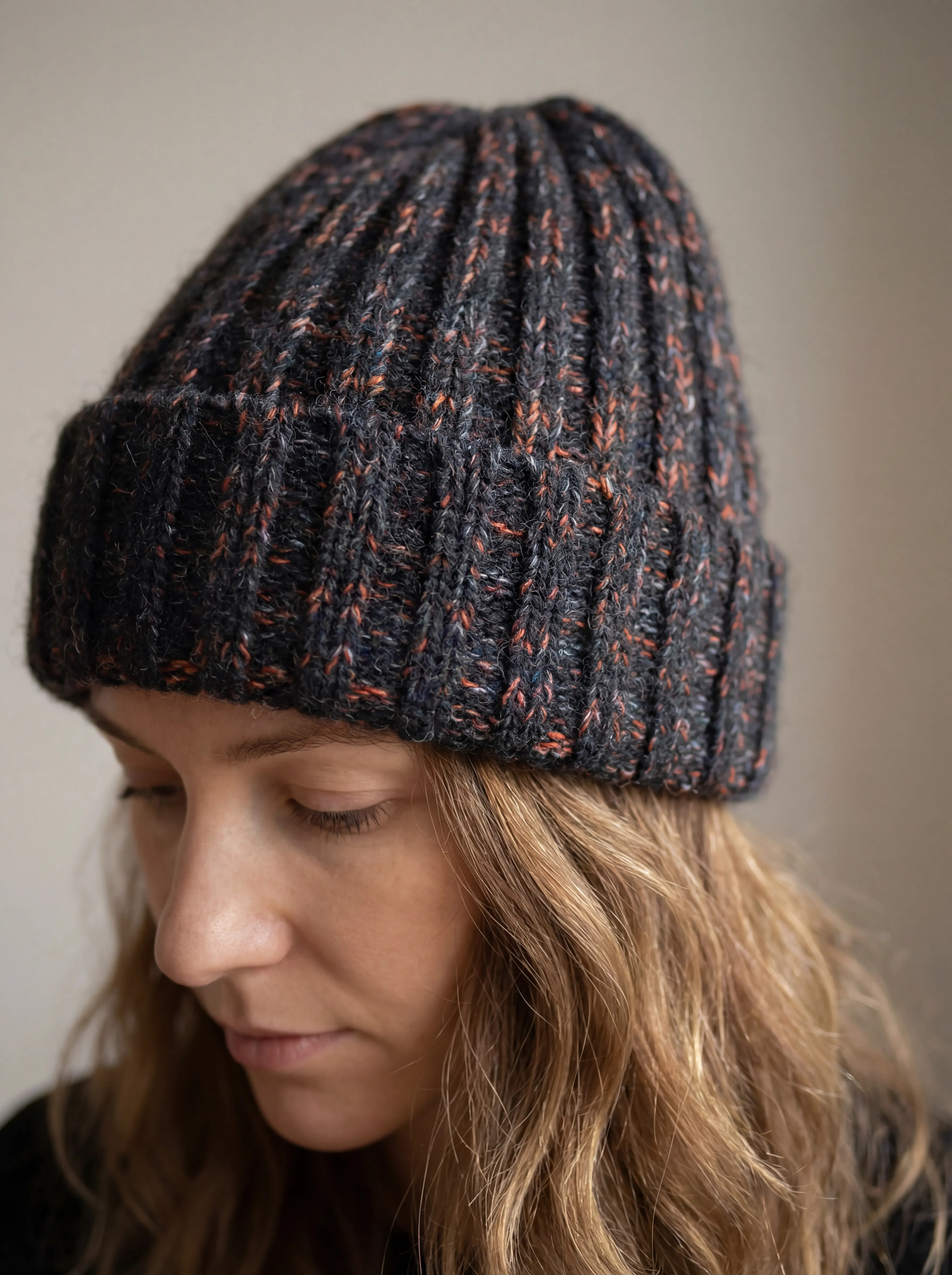 Closeup of chunky ribbed yak wool hat in mottled black and pink