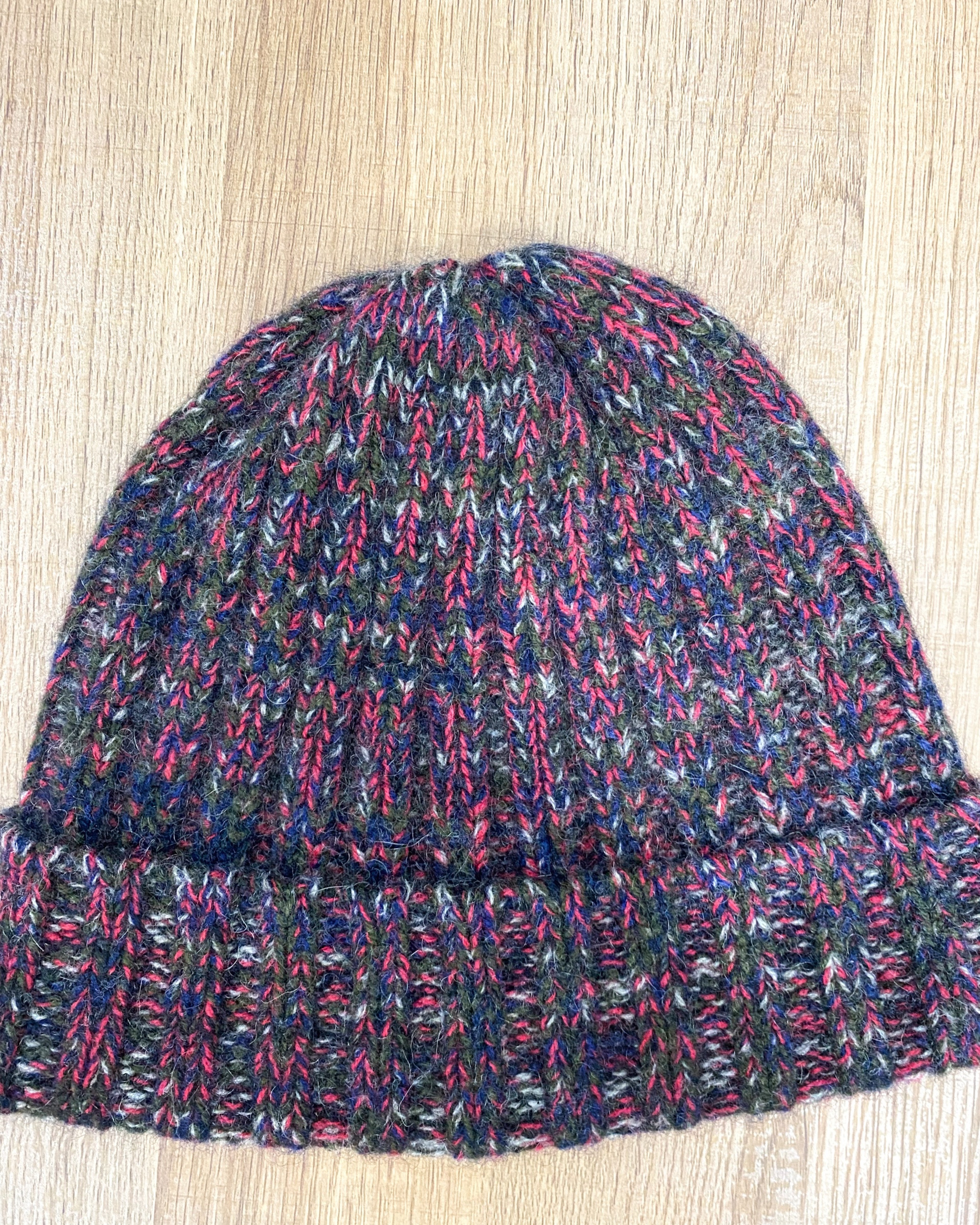 Lay flat picture of chunky ribbed yak wool hat in mottled red