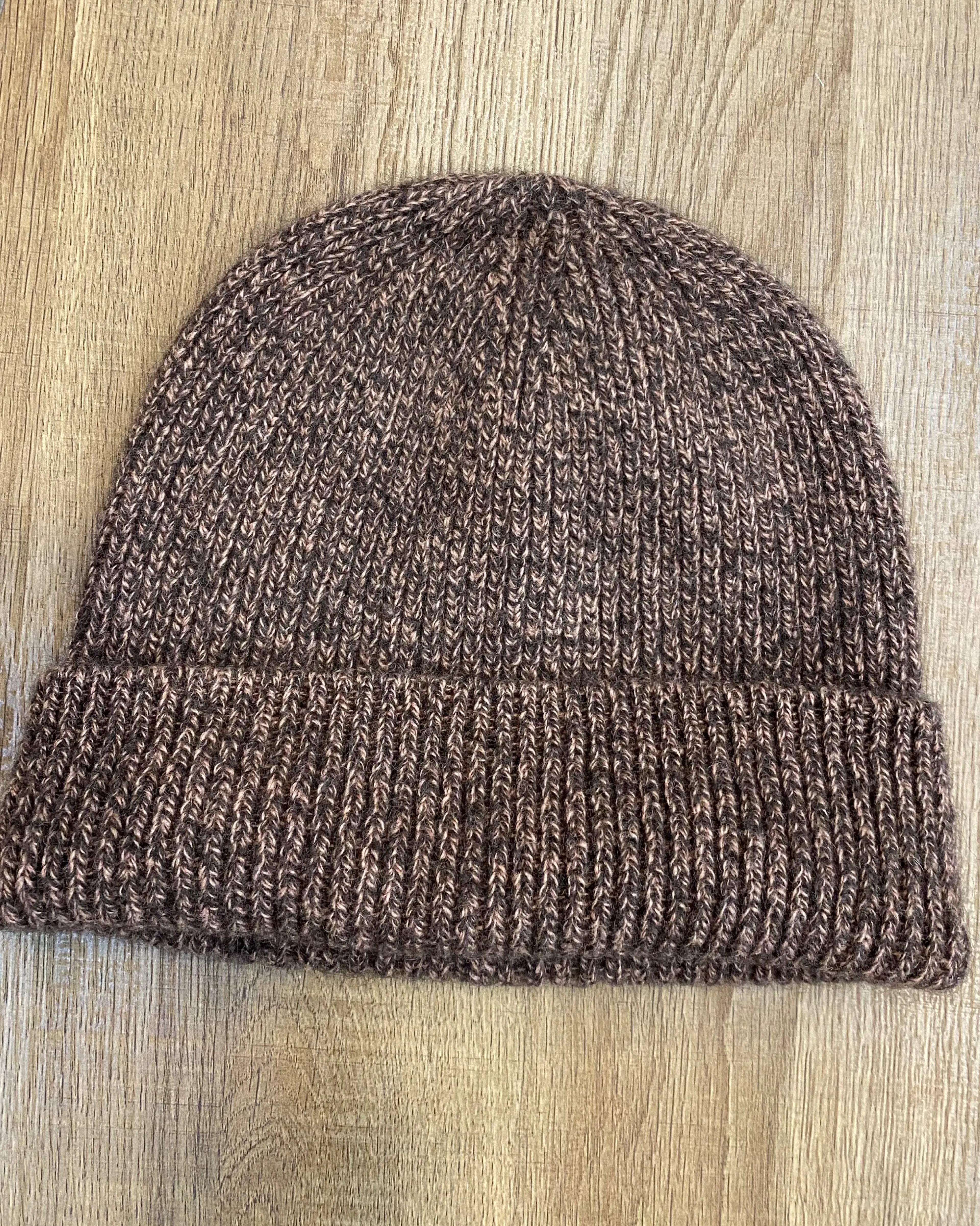 Lay-flat view of ribbed yak wool hat in mottled brown-pink