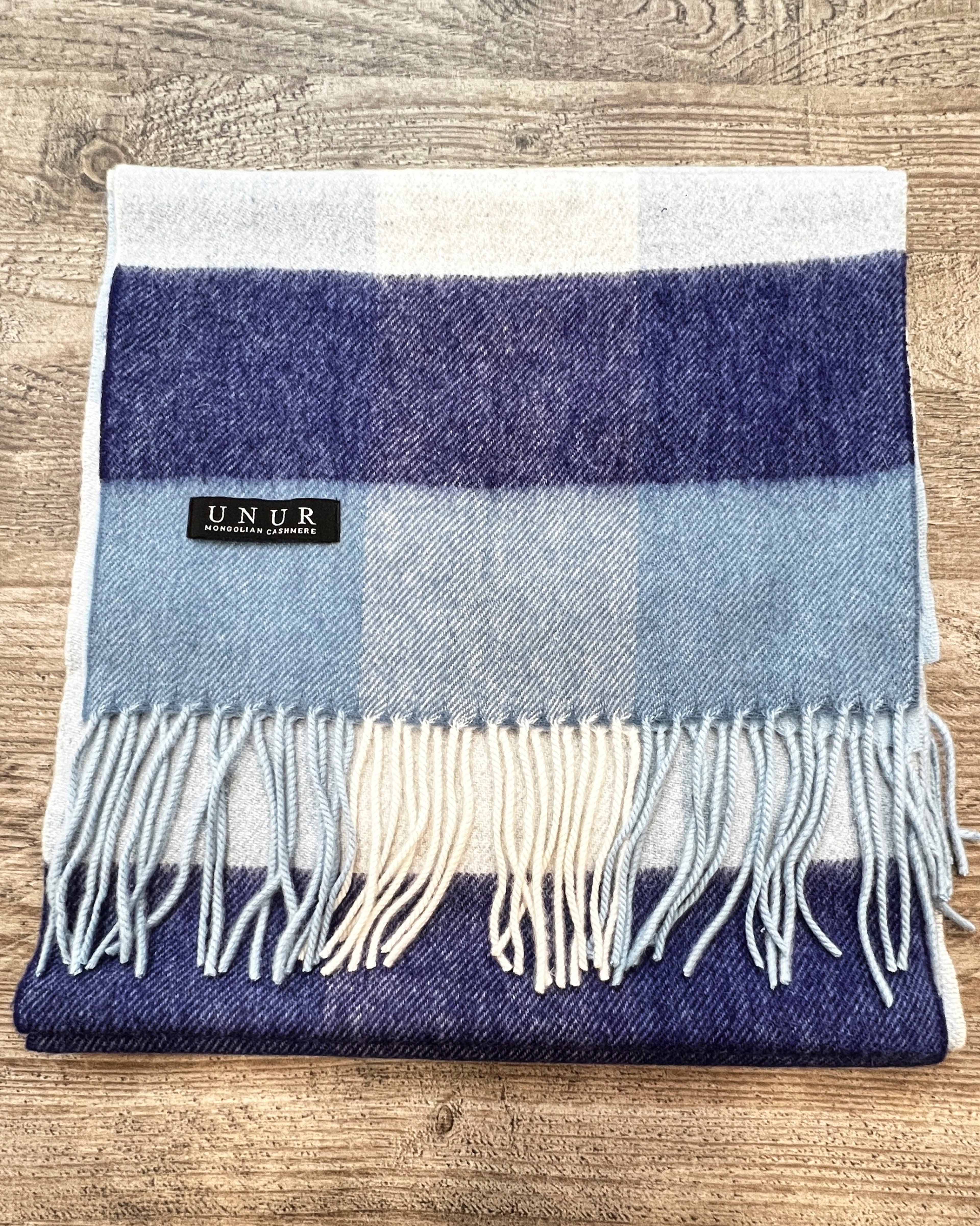 Lay-flat close up of check blue unisex woven cashmere scarf with tassles