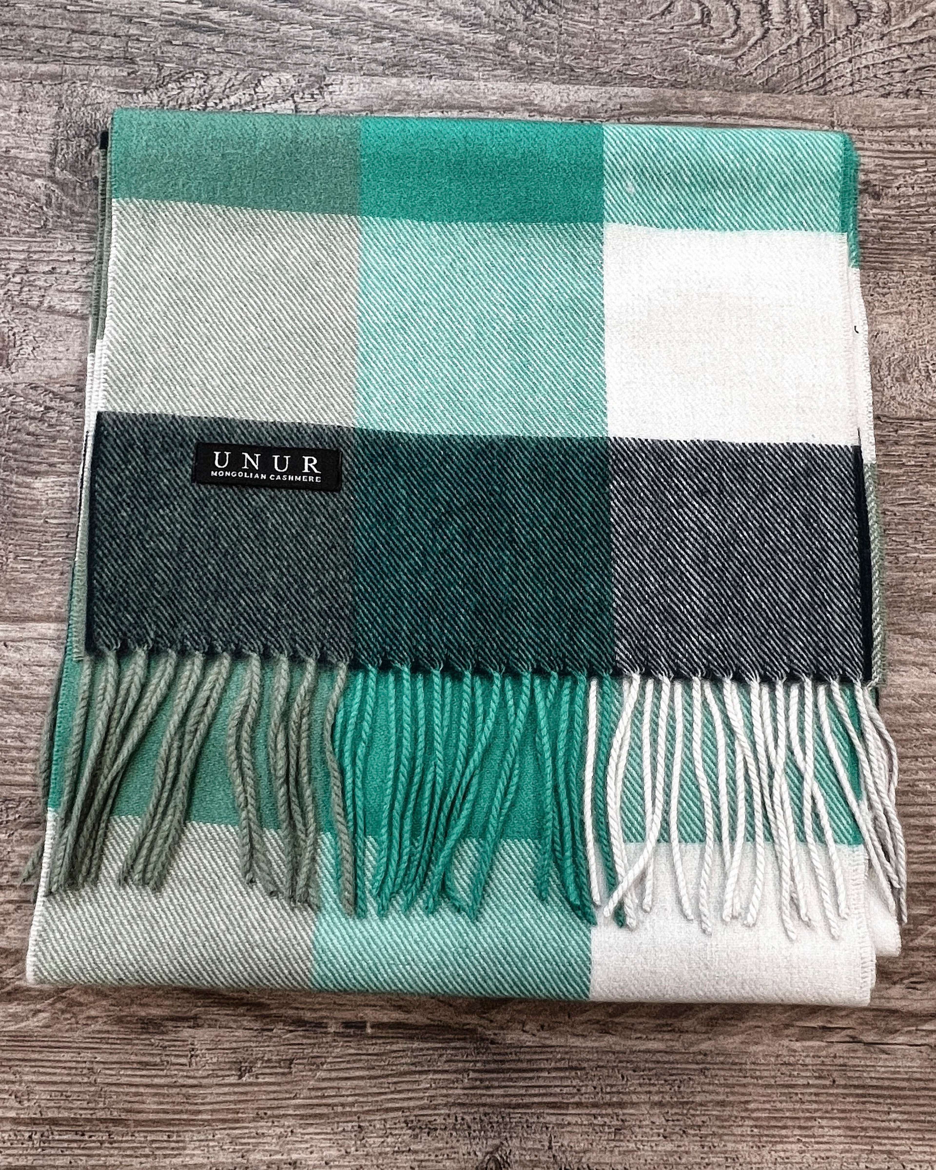 Lay-flat close up of check green unisex woven cashmere scarf with tassles