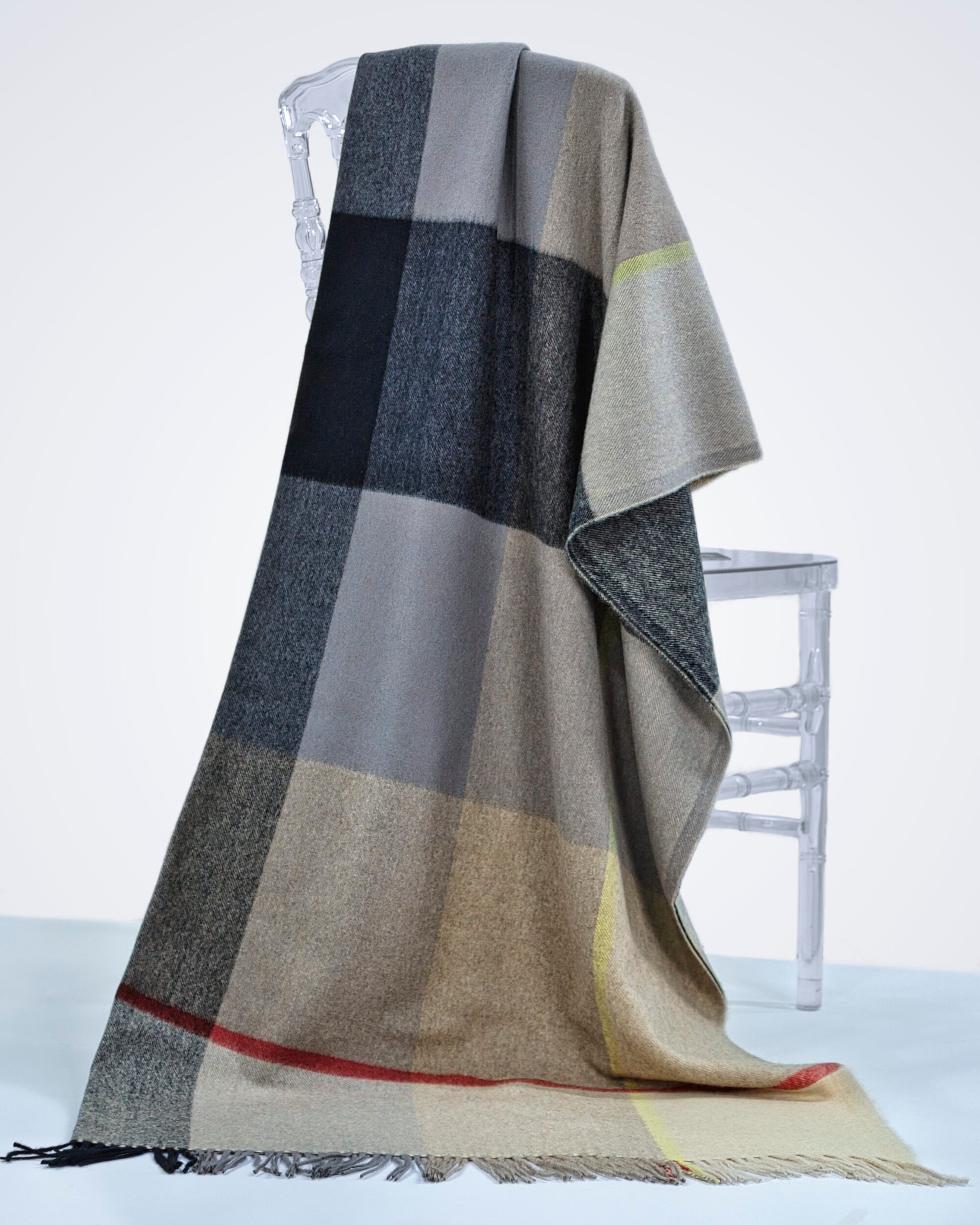 Cashmere checked pattern blanket with tassels, draped over a chair