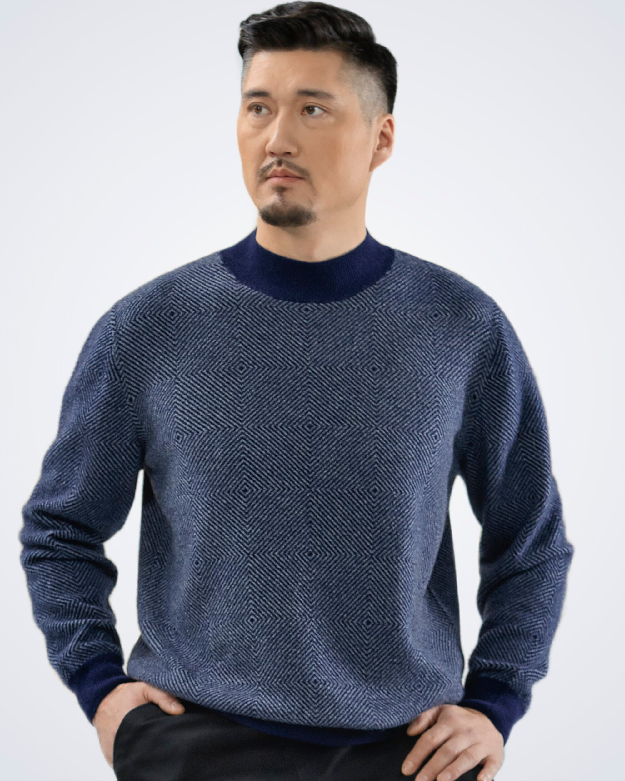 Man wearing a dark blue high neck cashmere jumper with diamond pattern, front view
