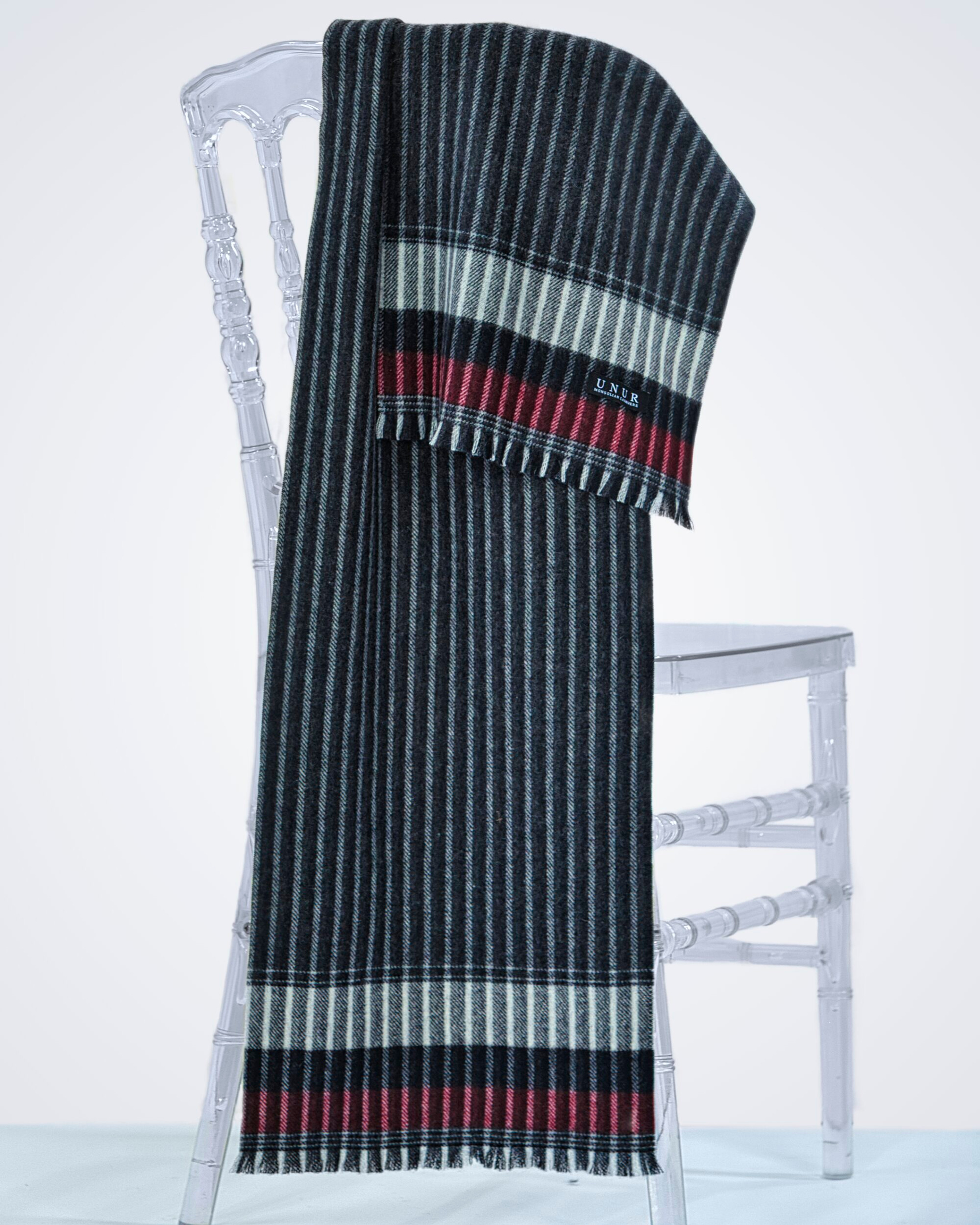 Unur model wearing a pinstripe cashmere scarf with plaid end detail