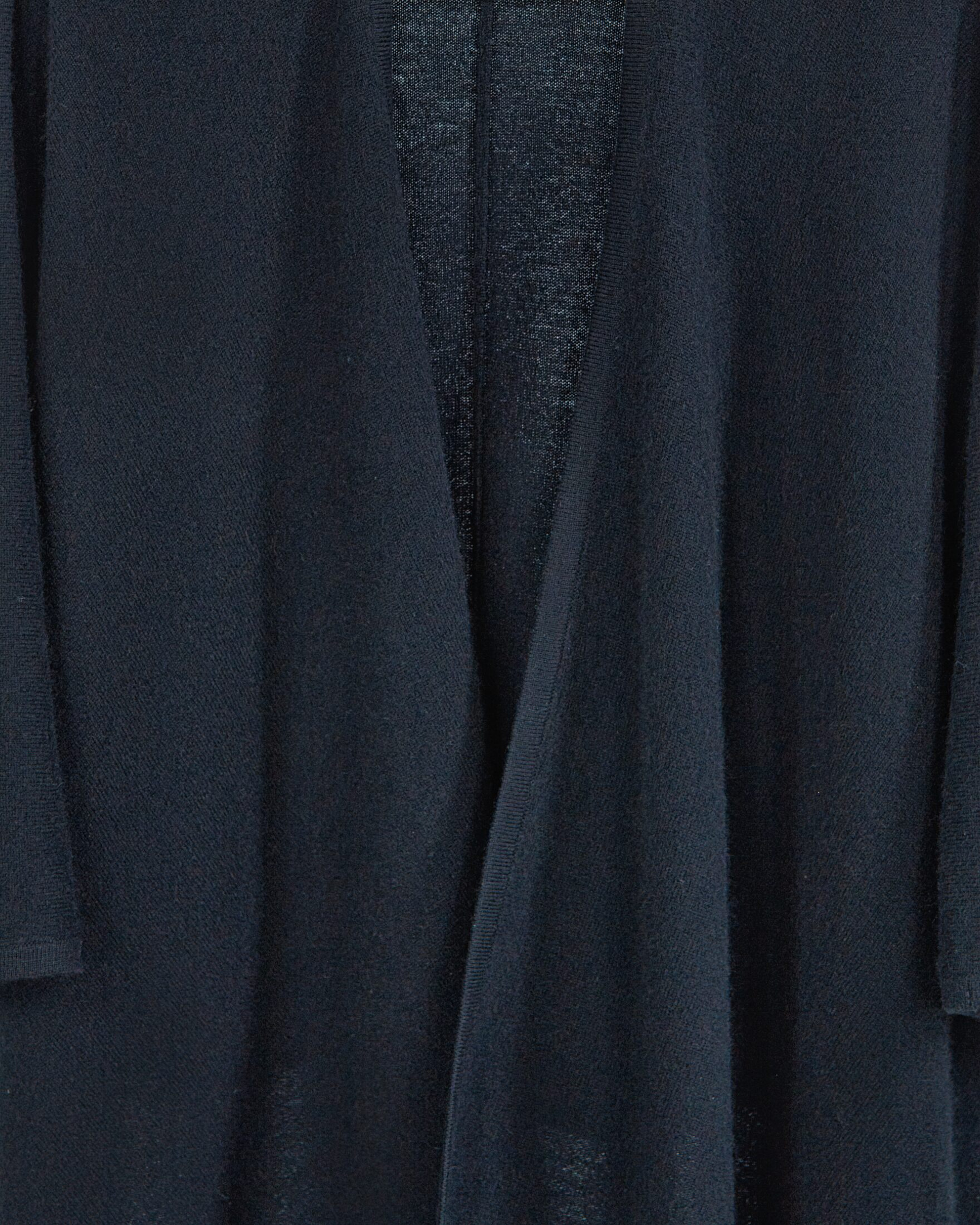 Close up of black cashmere cape with elegant draping and fluid silhouette