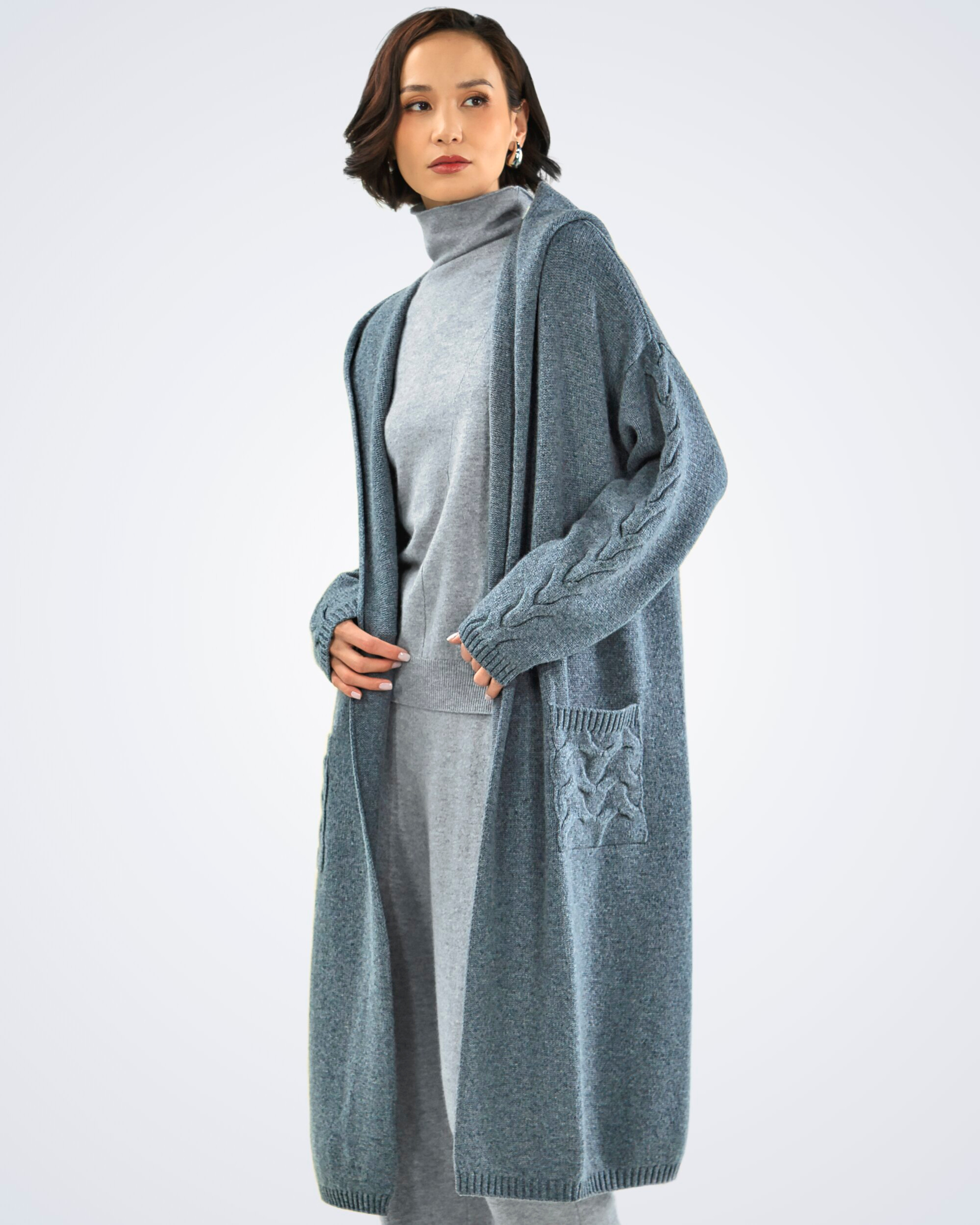 Unur model wearing a dark grey cable knit cashmere long cardigan with hoodie