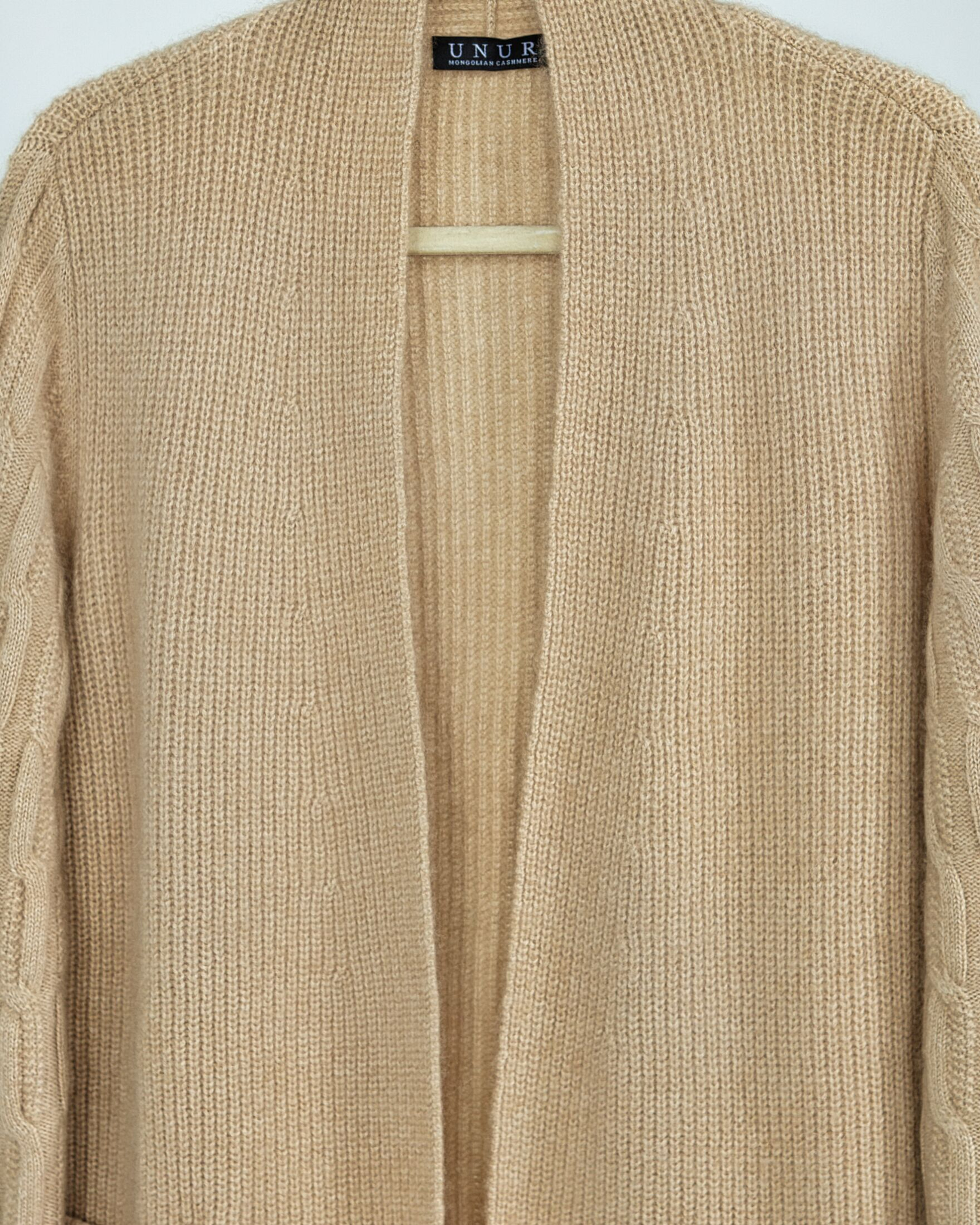 Close up of natural beige ribbed cashmere with cable detailing