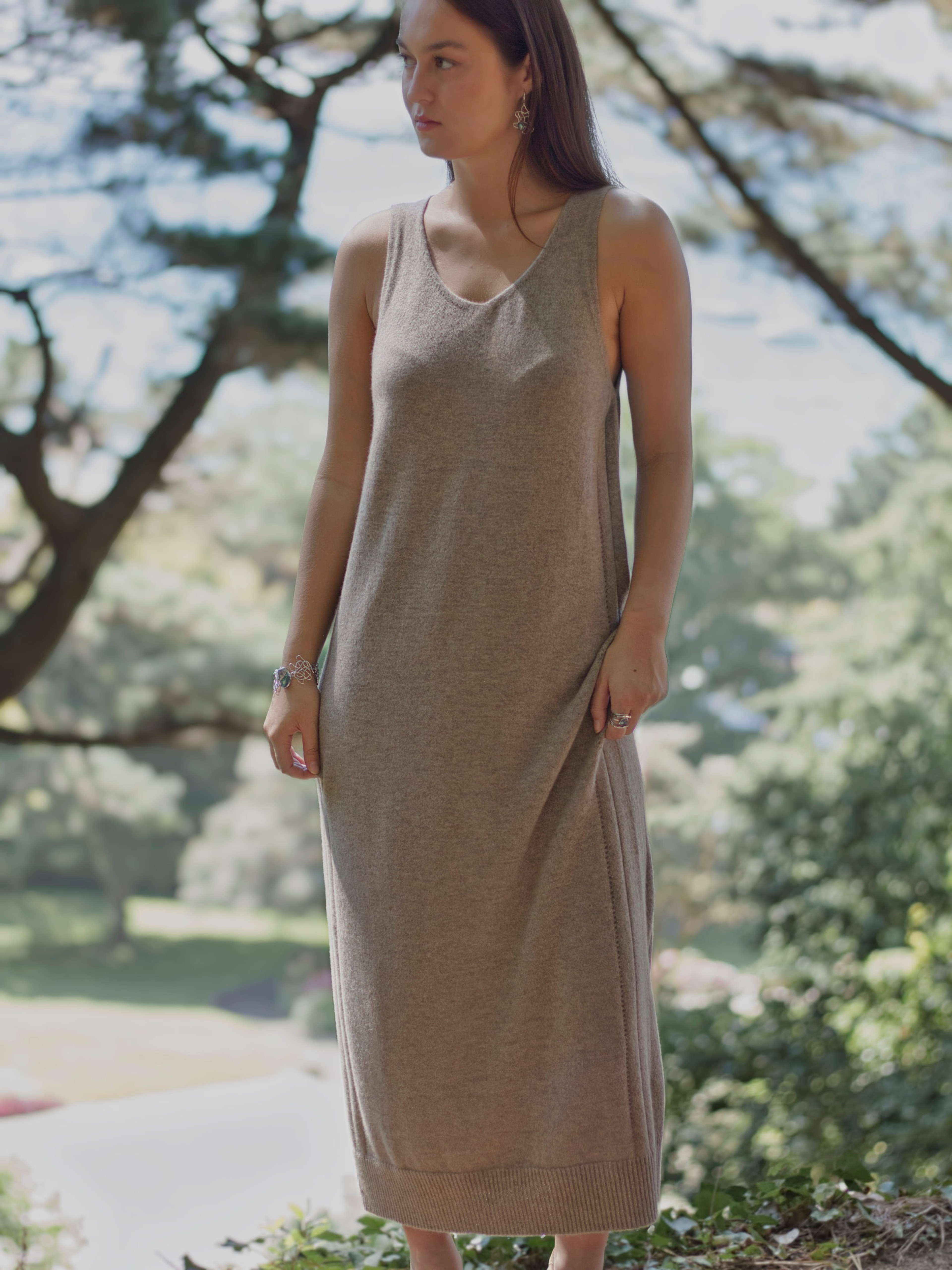 Model outdoors wearing a natural brown v-neck cashmere midi dress