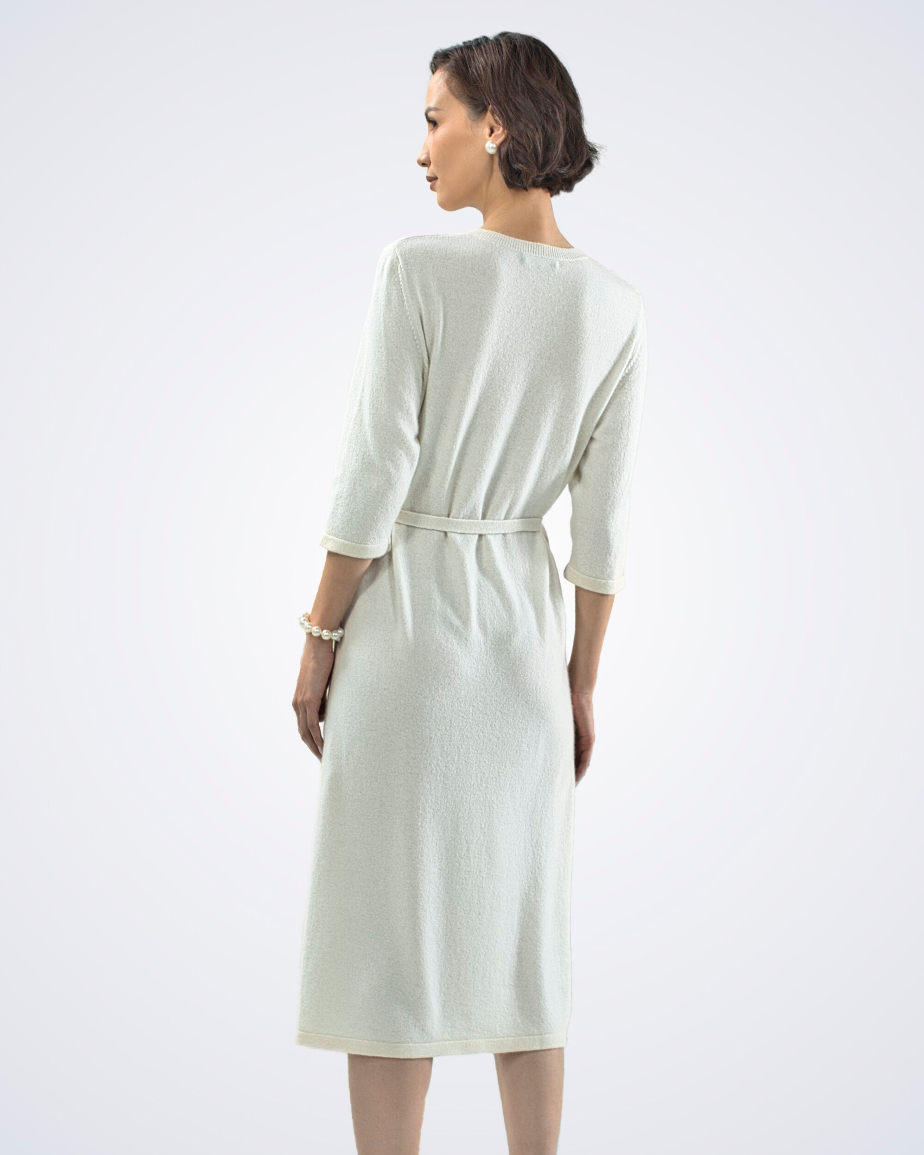 Unur model wearing a white three-quarter sleeve chevron cashmere midi dress, back view
