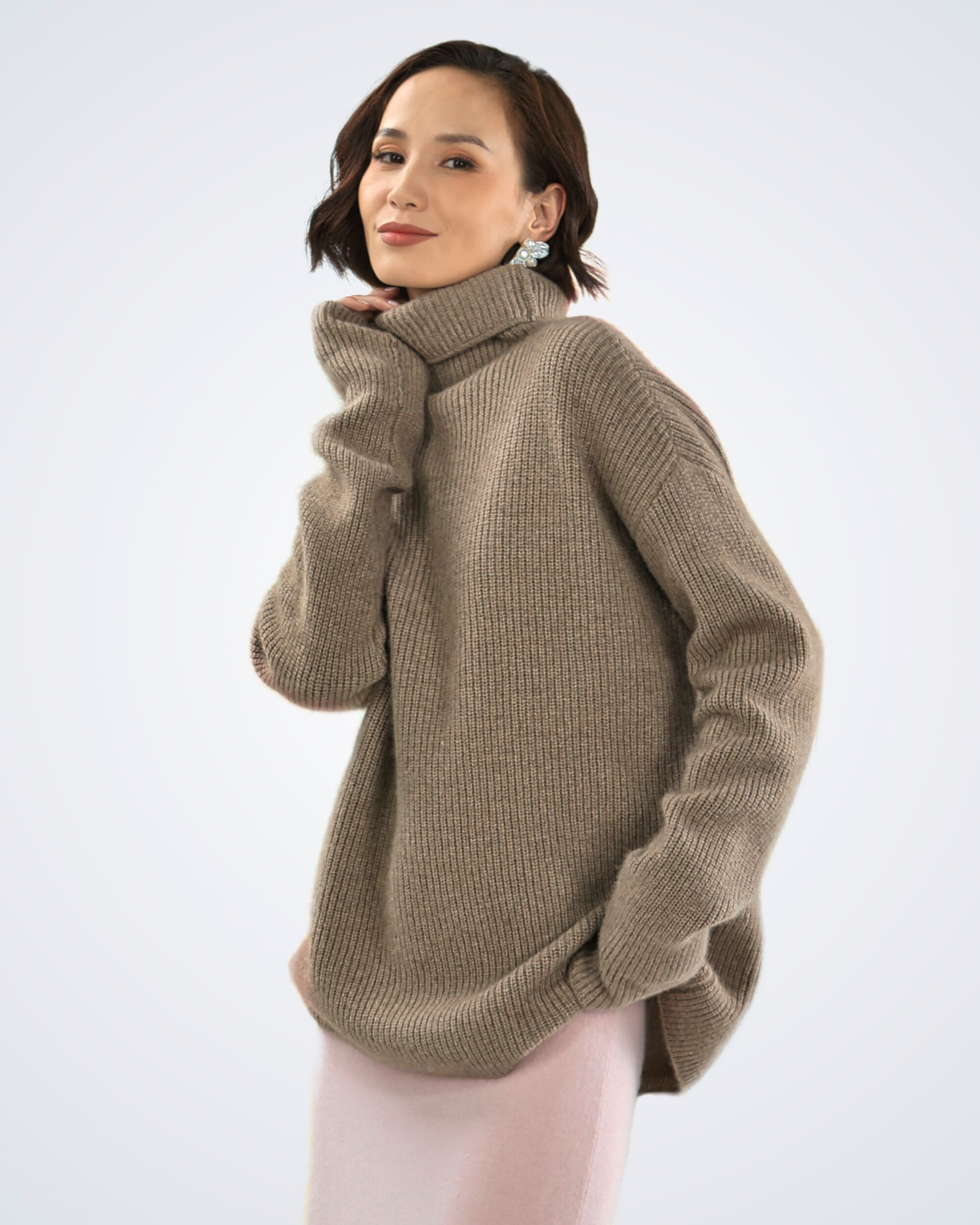 Unur model wearing an oversized roll neck ribbed cashmere jumper in natural brown