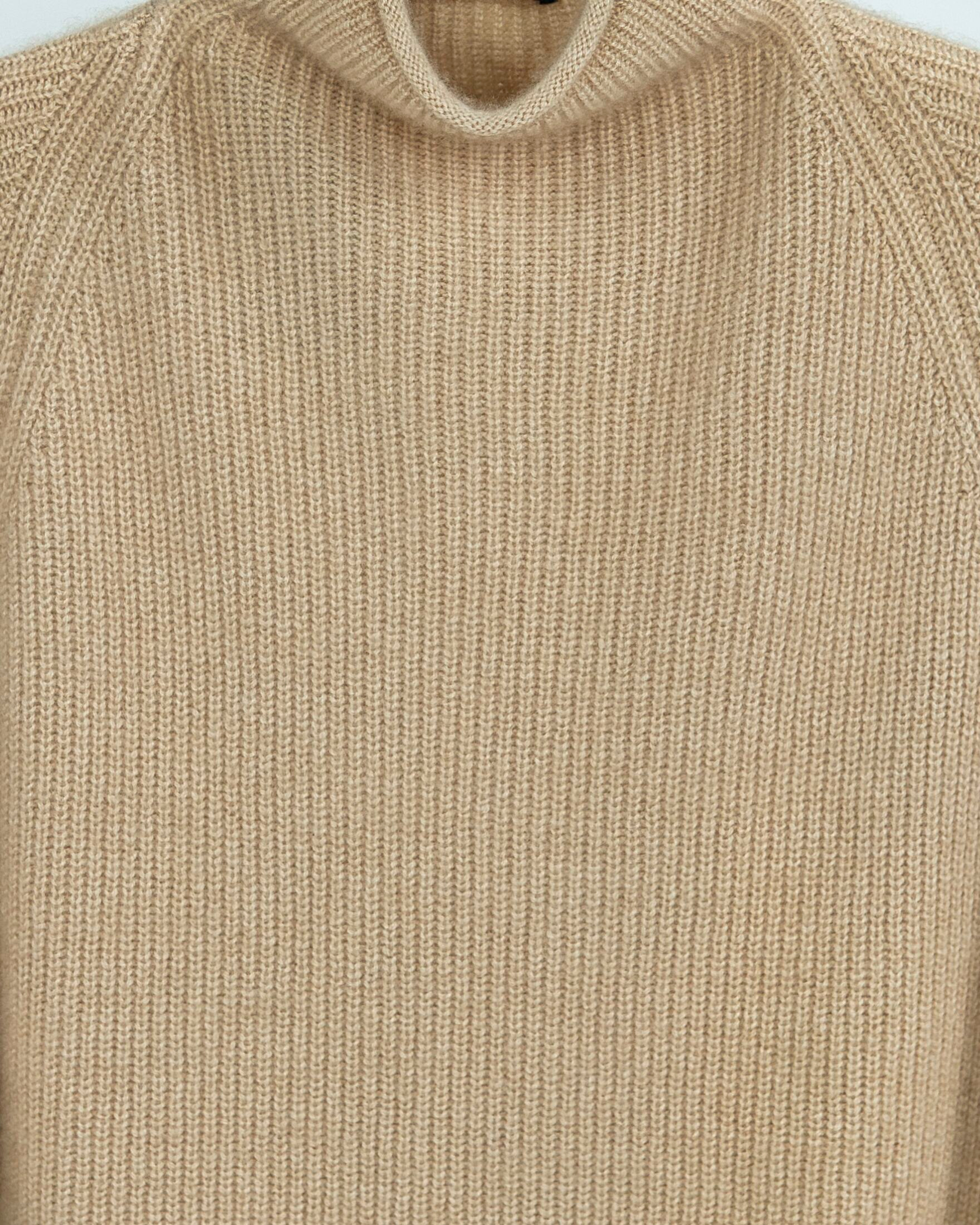 Close up of a natural beige oversized high-neck ribbed cashmere jumper