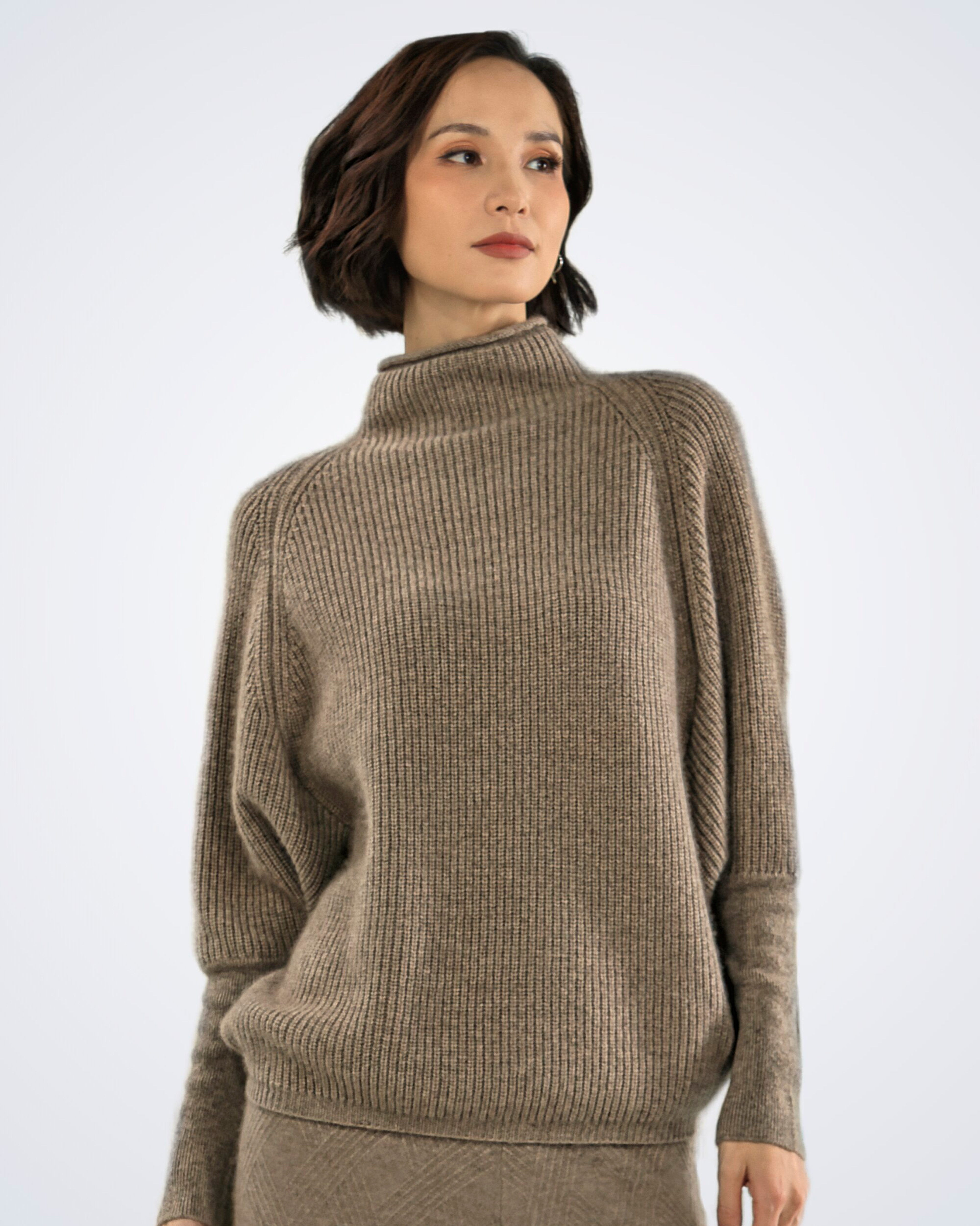 Unur model wearing an oversized high-neck ribbed cashmere jumper in natural brown