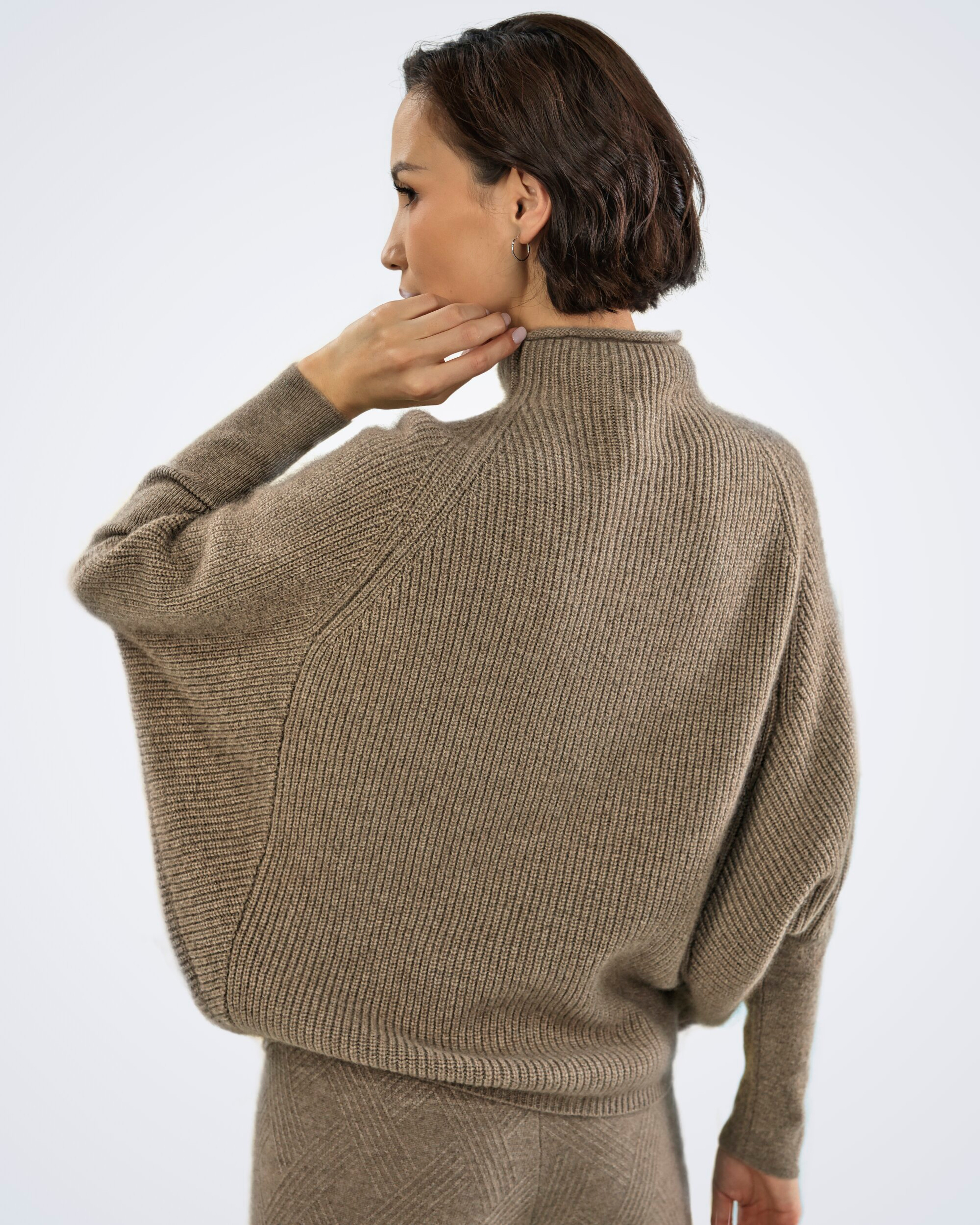 Unur model wearing the back of an oversized high-neck ribbed cashmere jumper in natural brown