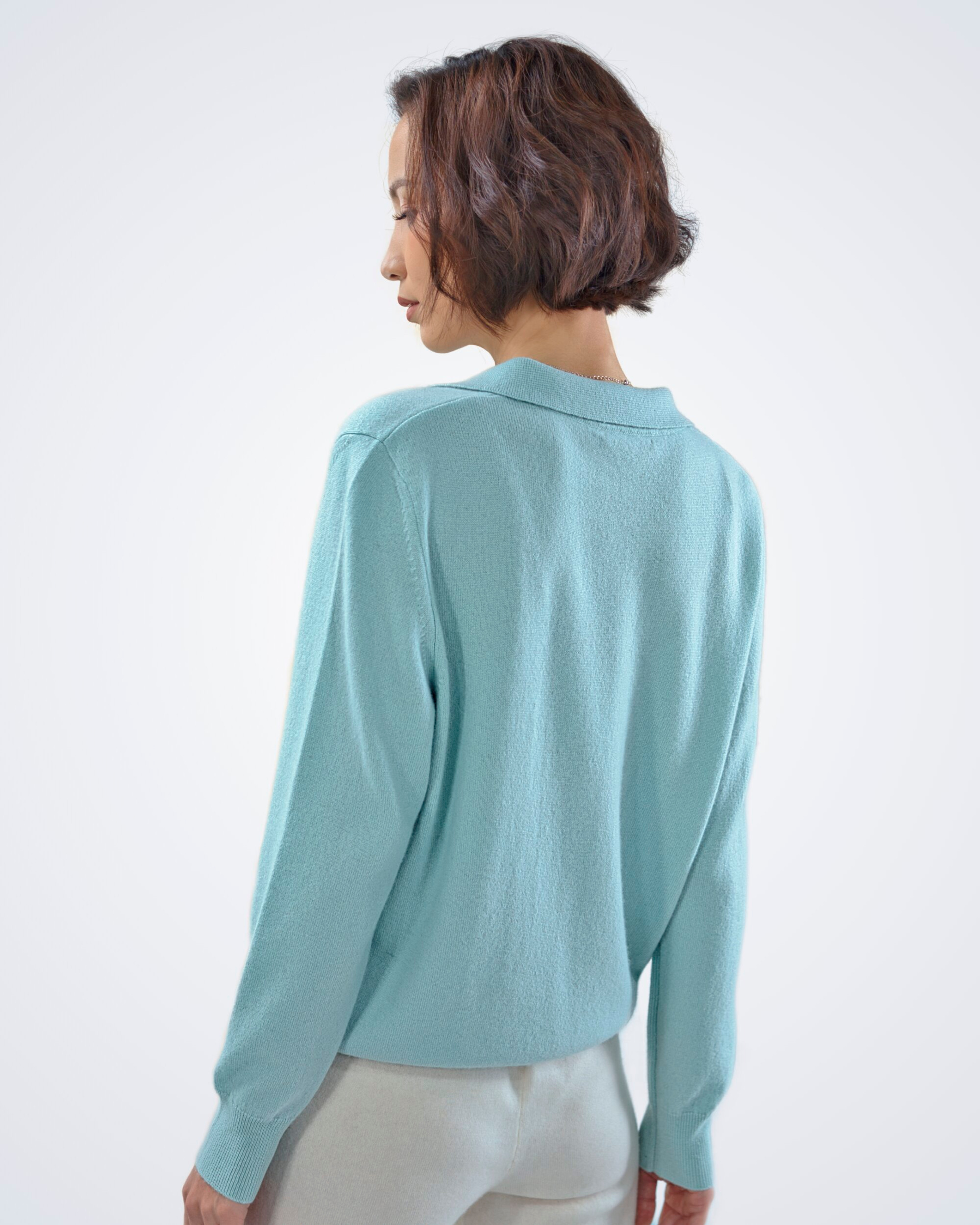 Unur model wearing a mint green cashmere jumper with a shirt collar, shown from the back