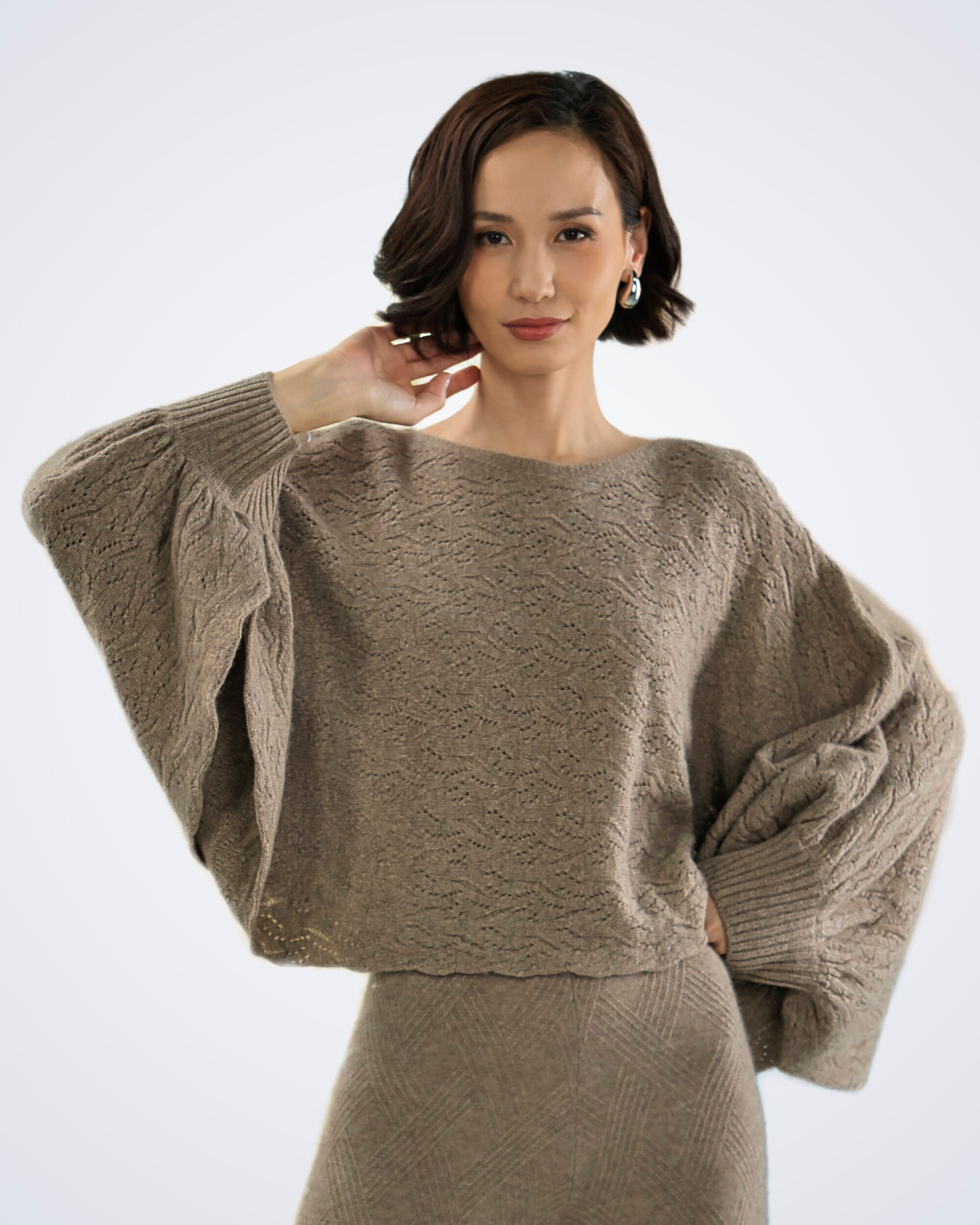 Unur model wearing a natural brown patterned loose-knit cashmere poncho-style jumper