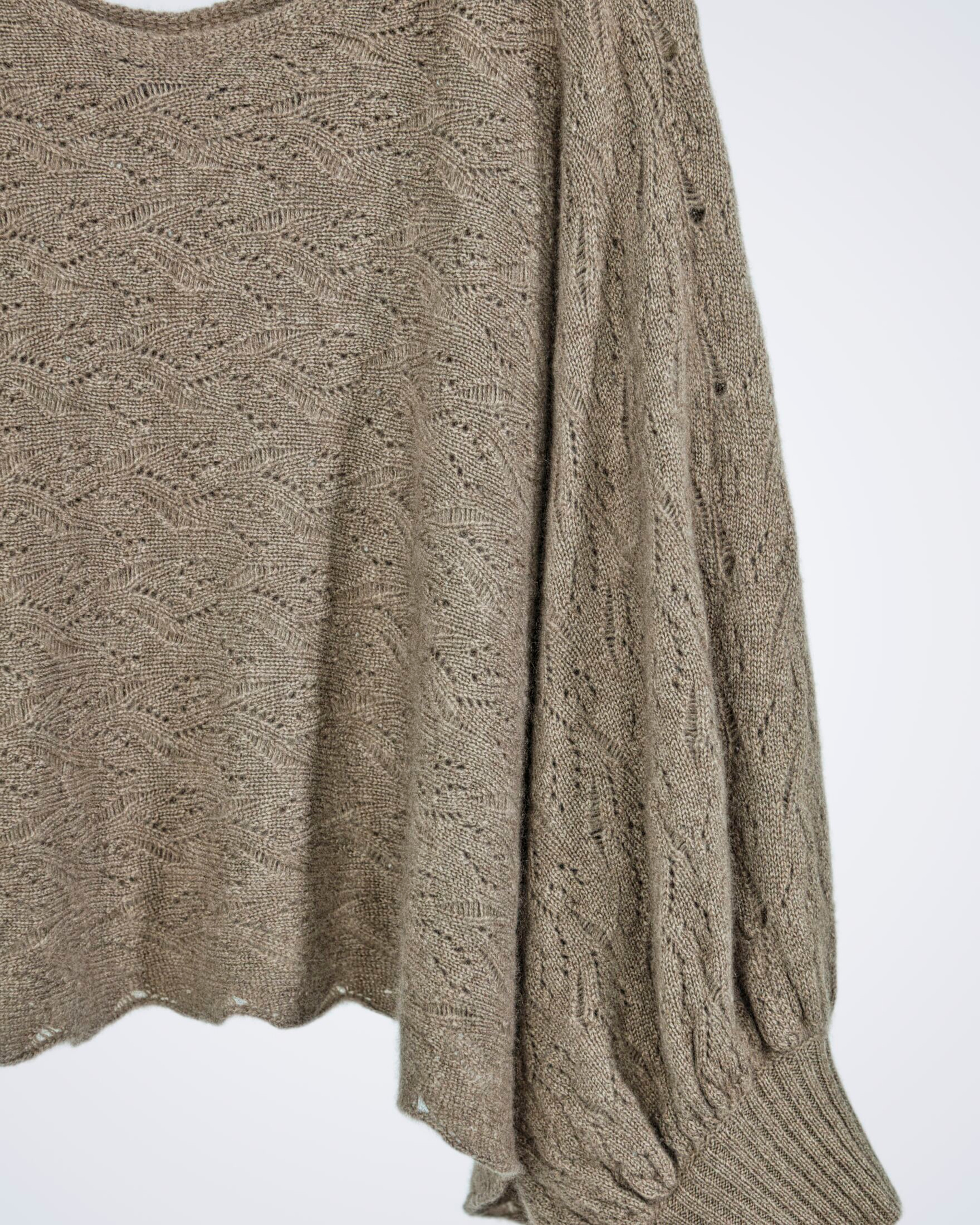 Close up of natural brown patterned loose-knit cashmere poncho-style jumper