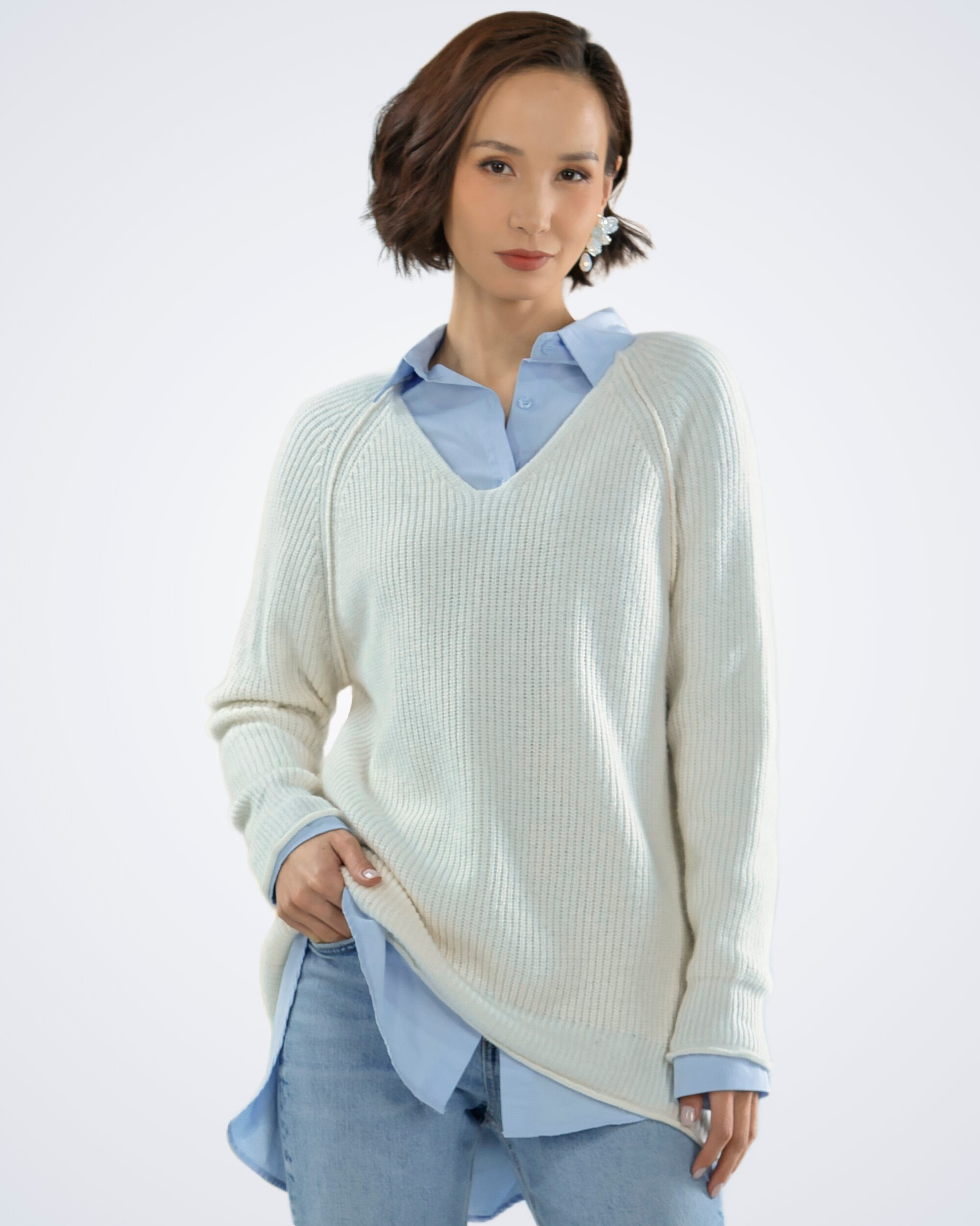 Unur model wearing a white V-neck ribbed cashmere jumper with exposed seams