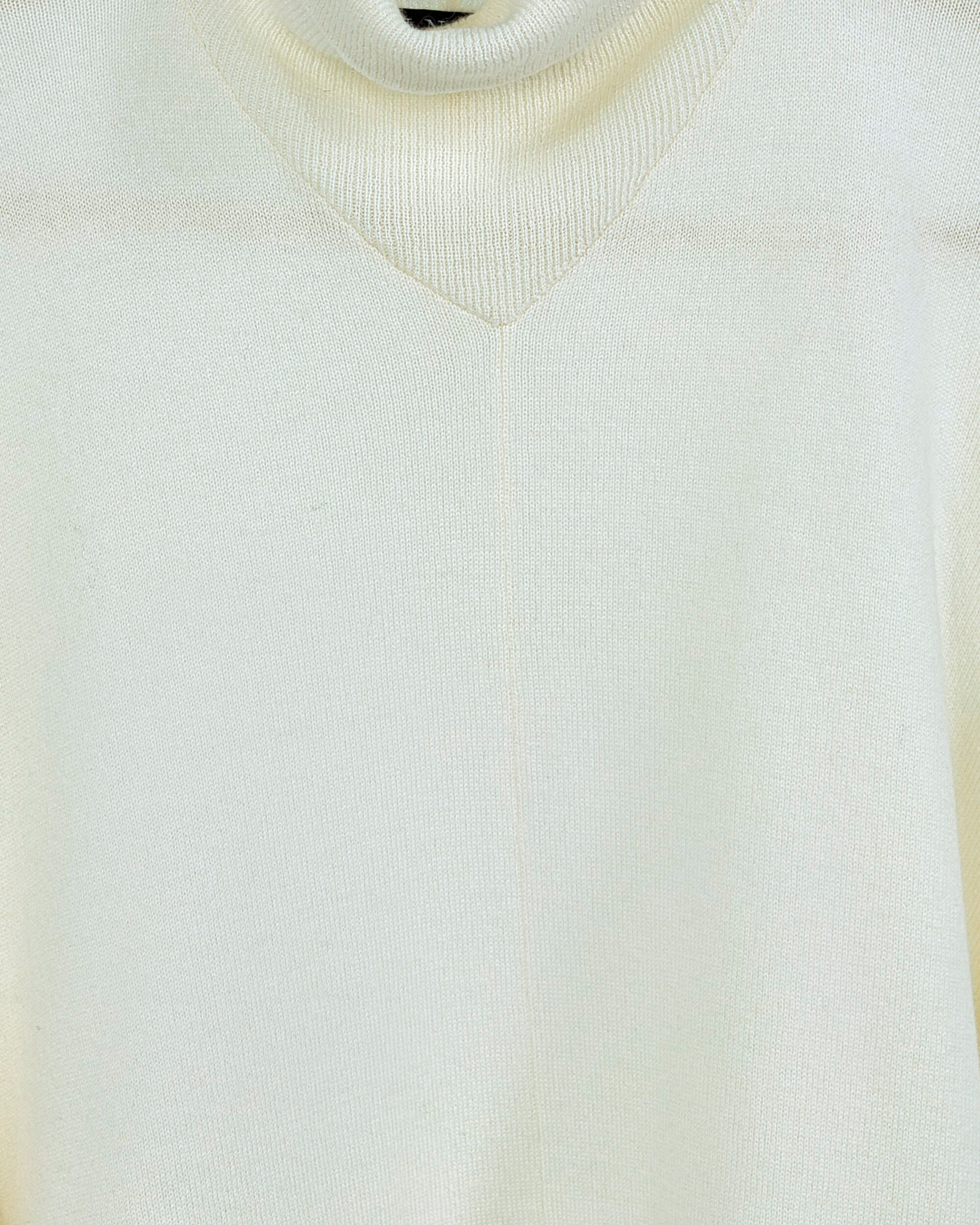 Close up of white cashmere poncho with ribbing