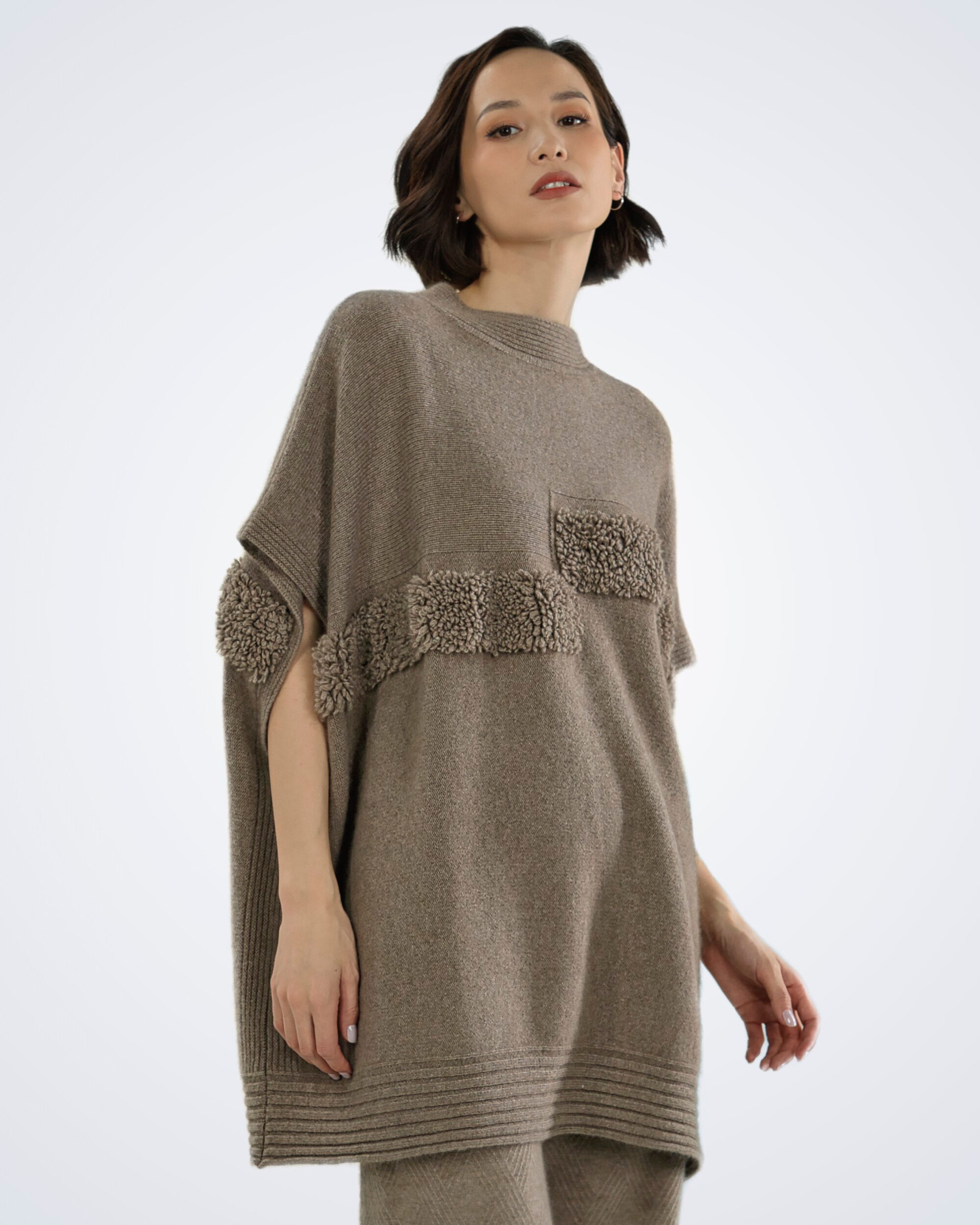 Unur model wearing a natural brown ribbed cashmere poncho with faux fur trim