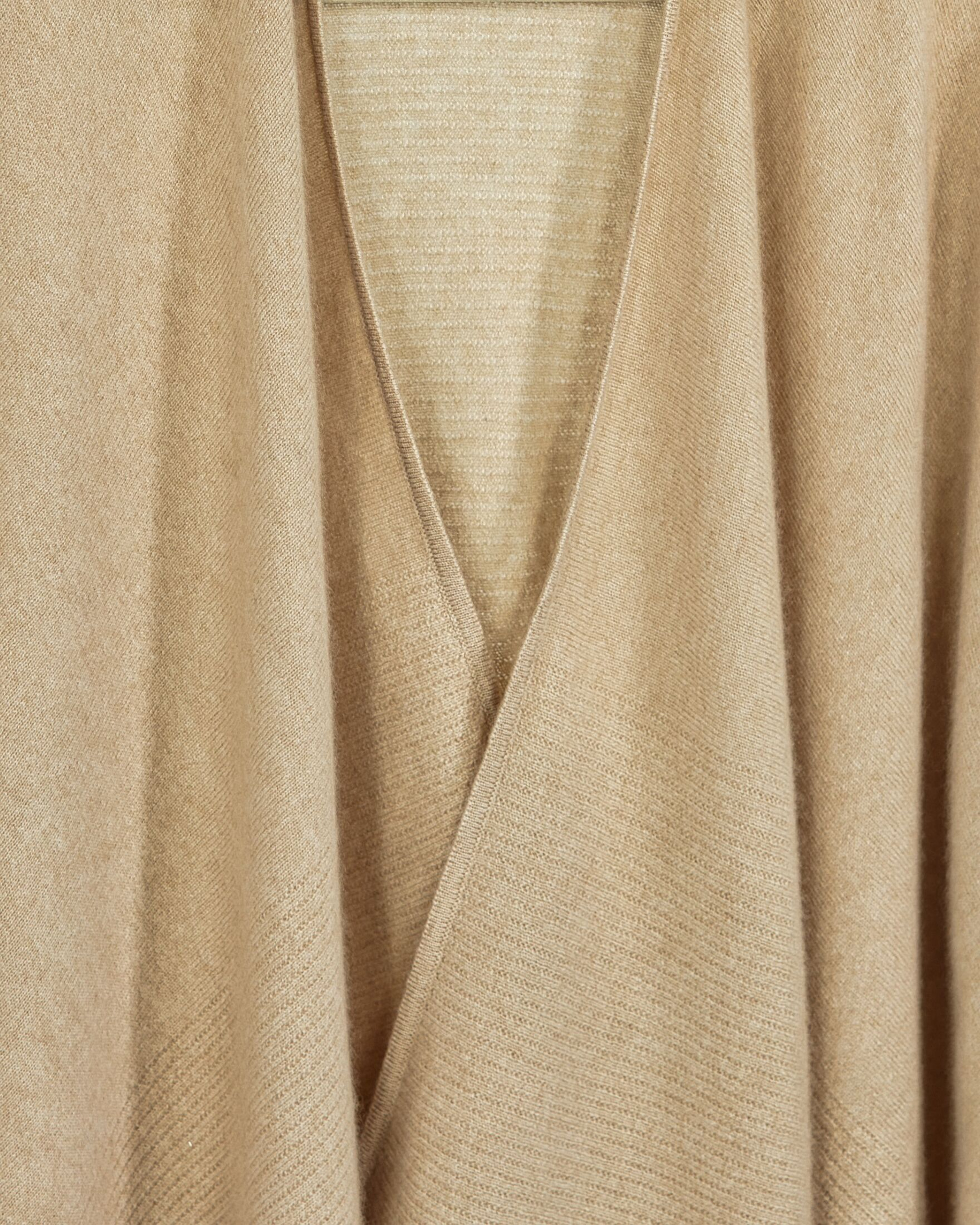 Close up of open-front cashmere poncho in natural beige with ruched sleeves