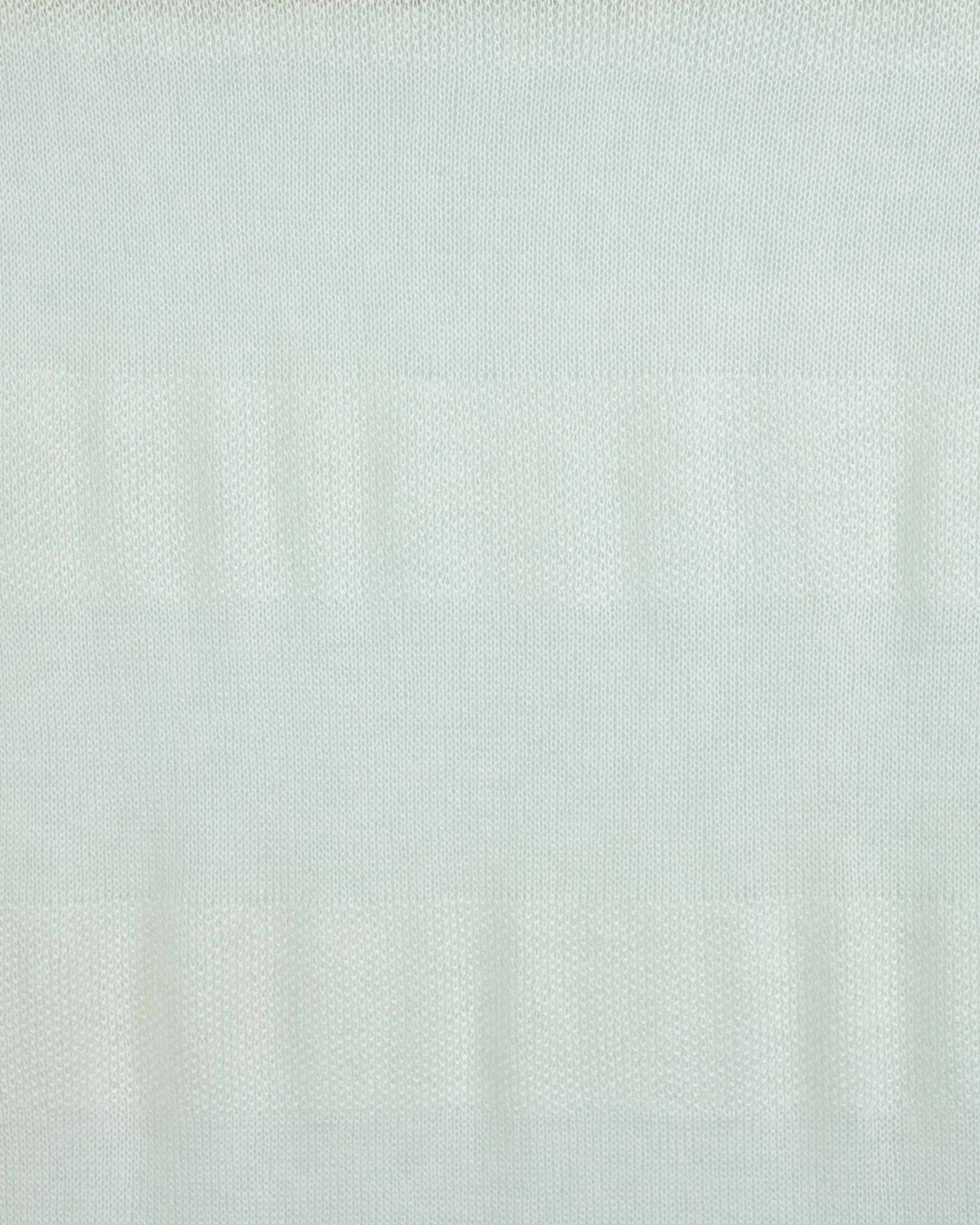 Close up of a white cashmere shawl with a delicate patterned knit