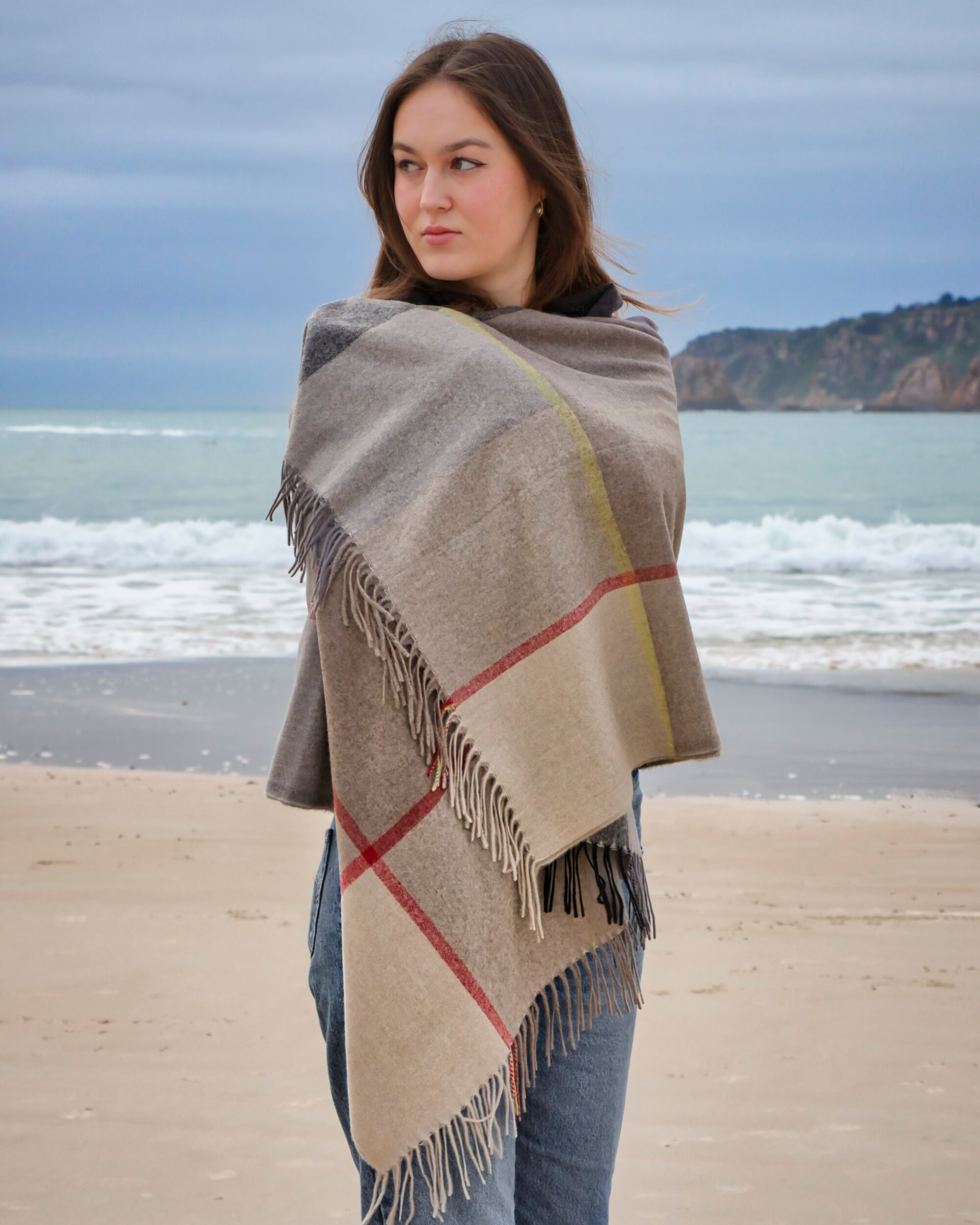 Unur model wearing a checked plaid cashmere wrap shawl in brown and grey tones