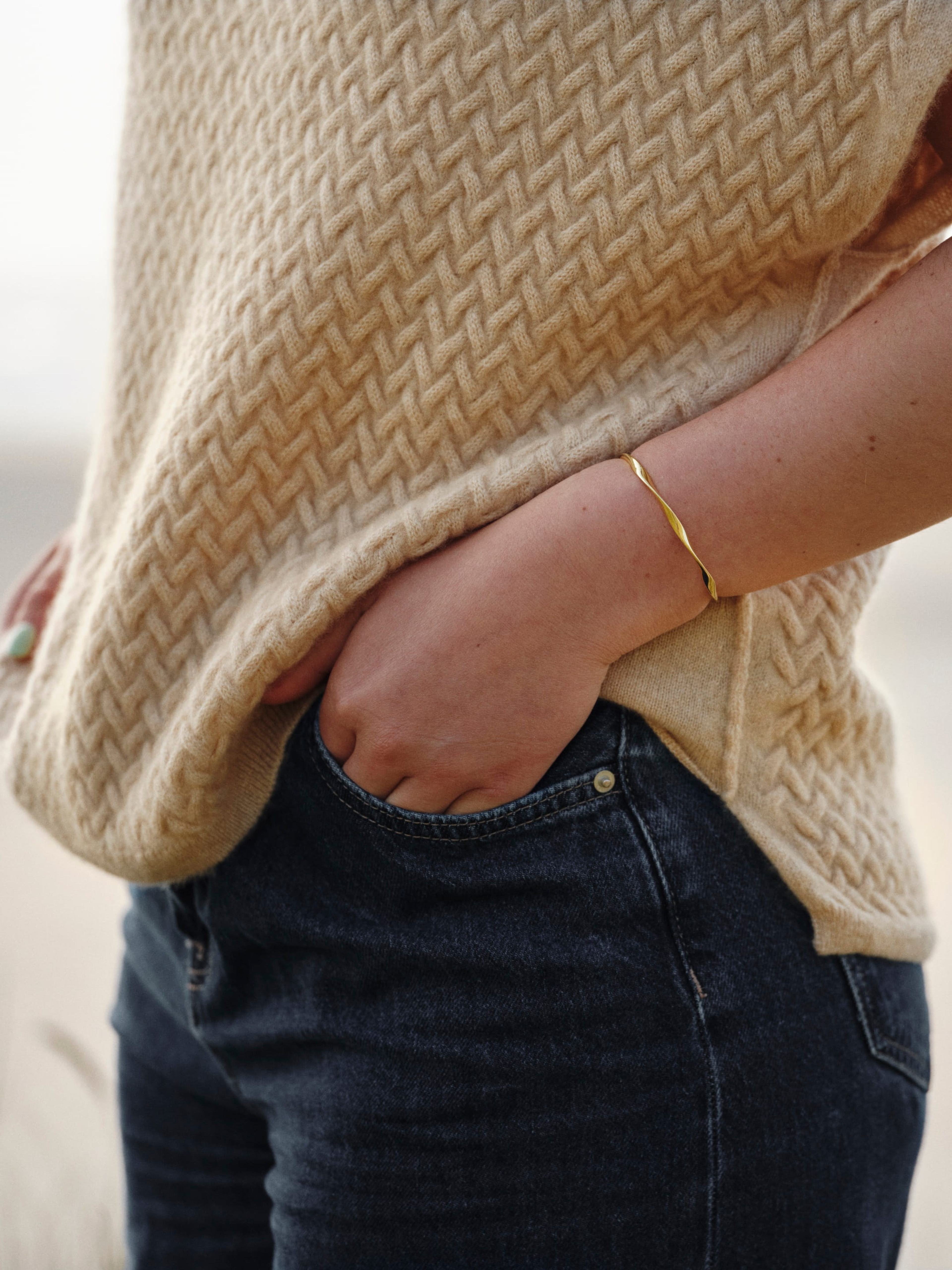 Close up of model wearing a natural beige luxury cable knit cashmere vest