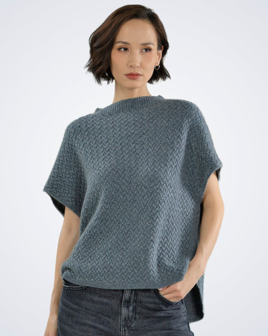 Woman wearing a grey luxury cable knit cashmere vest, front view