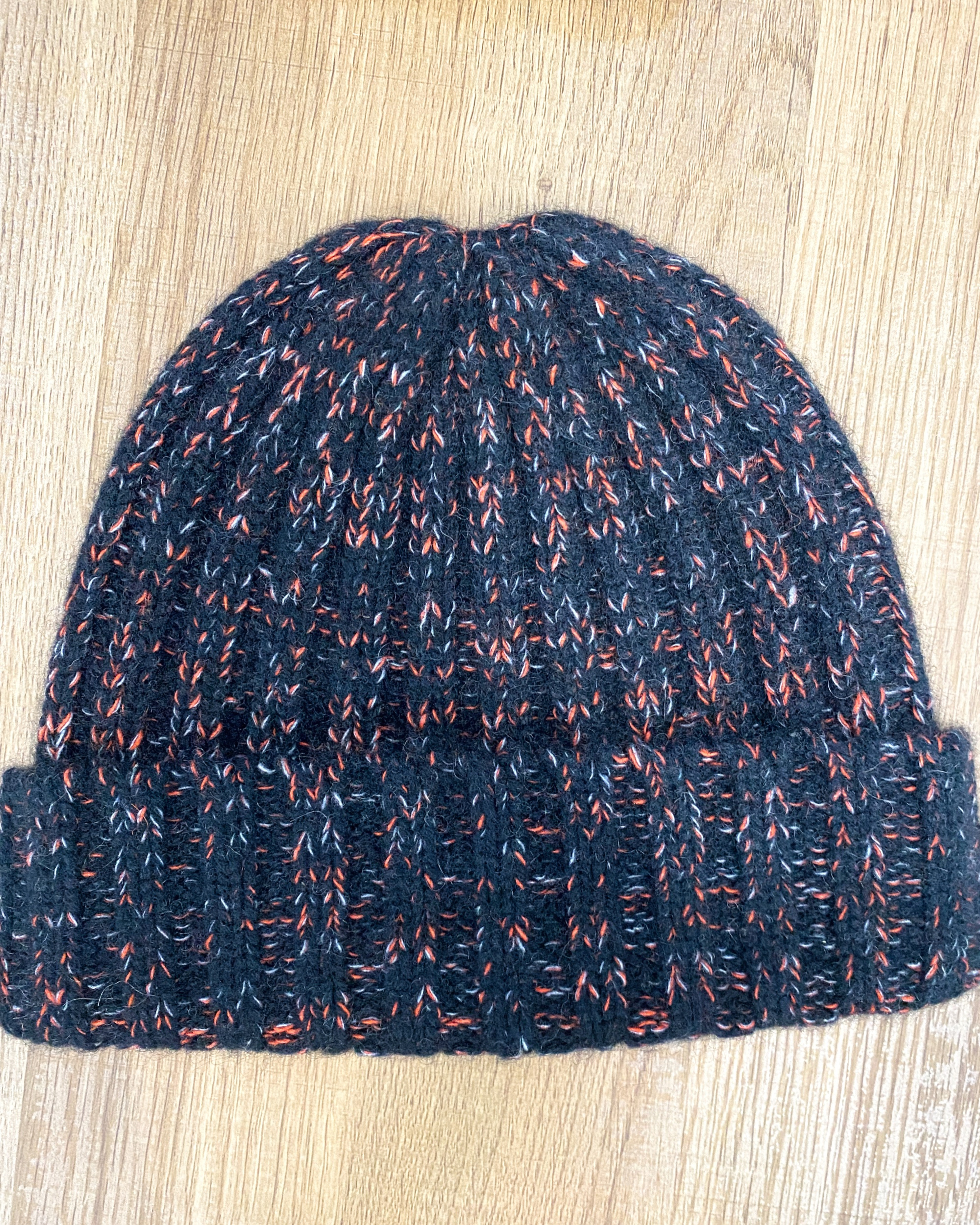 Black-pink yak wool hat on neutral background, flat view