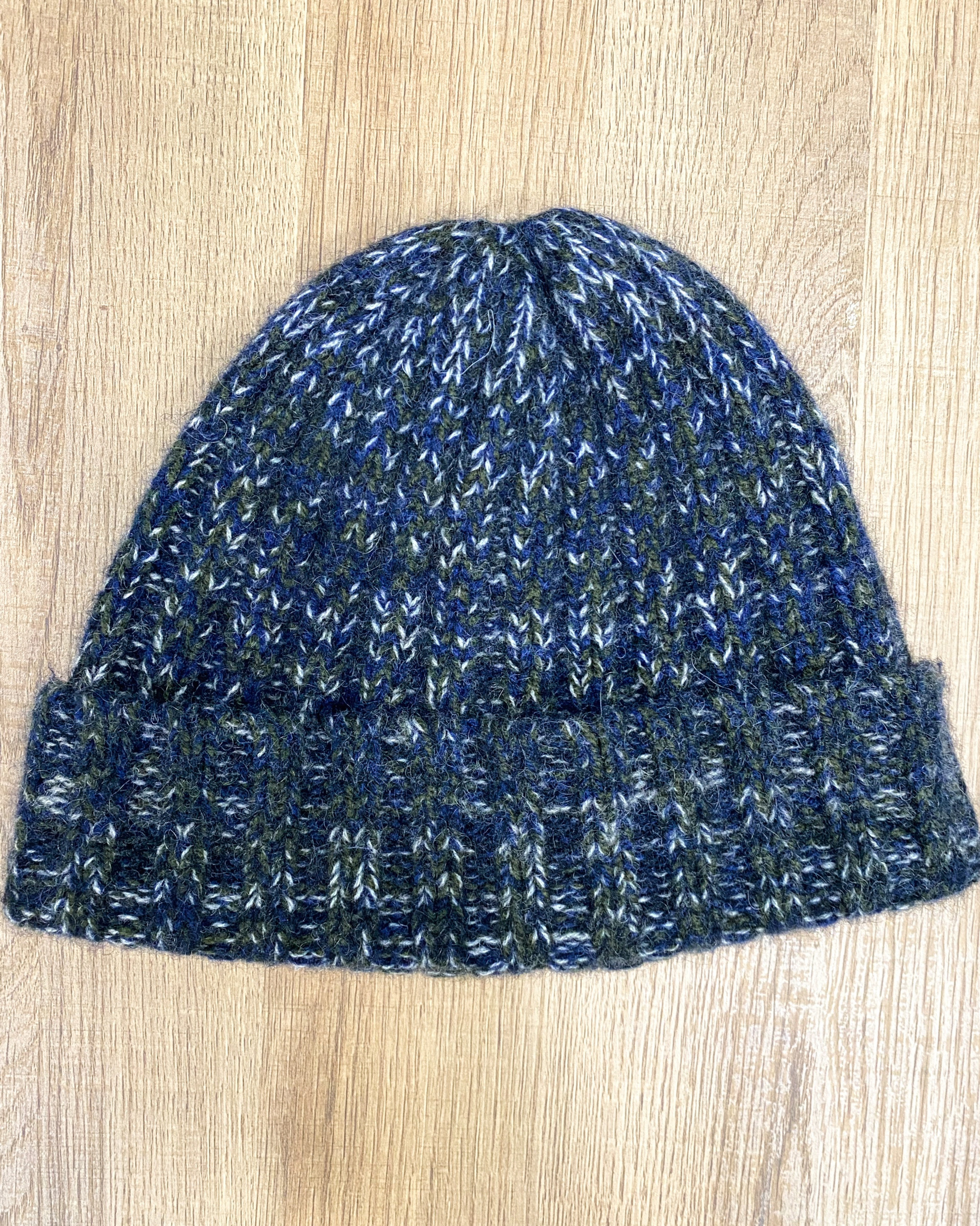 Blue-green yak wool hat on neutral background, flat view